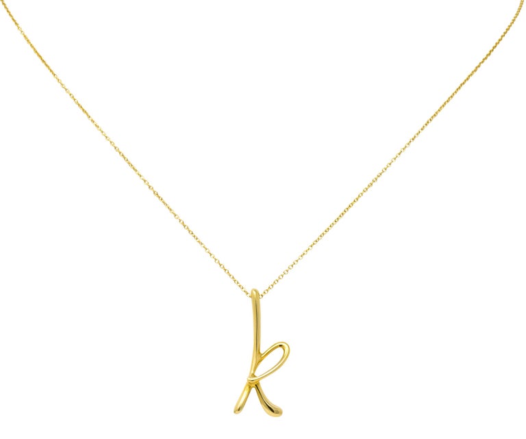 Featuring a stylized letter 'k' of high polished 18 karat gold

Accompanied by 18 karat gold cable style chain with spring ring clasp

Fully signed 750 (for 18 karat gold) Tiffany & Co. Spain with Paloma Picasso makers mark

Measures: letter 'k'