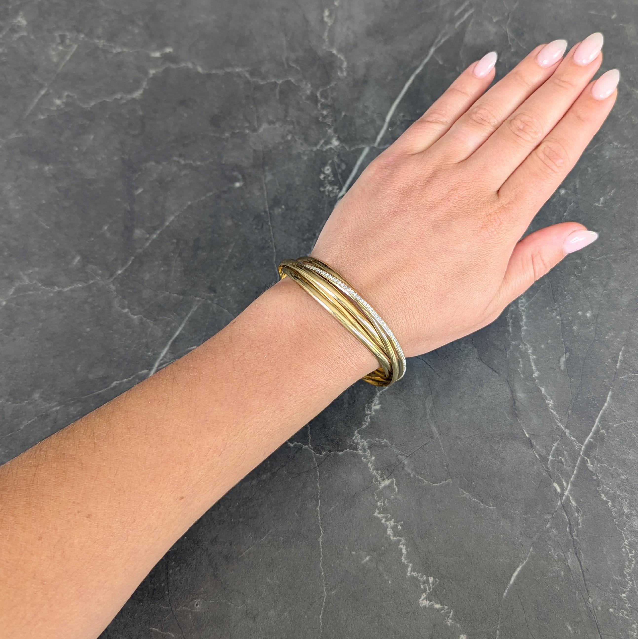 Compuesto por anillos redondos entrelazados de oro amarillo
Diseñado con superficie curvada y acabado de alto pulido
Con una cuenta brazalete engastada con diamantes
Talla brillante redonda y se completamente alrededor
Con un peso aproximado de 3.84