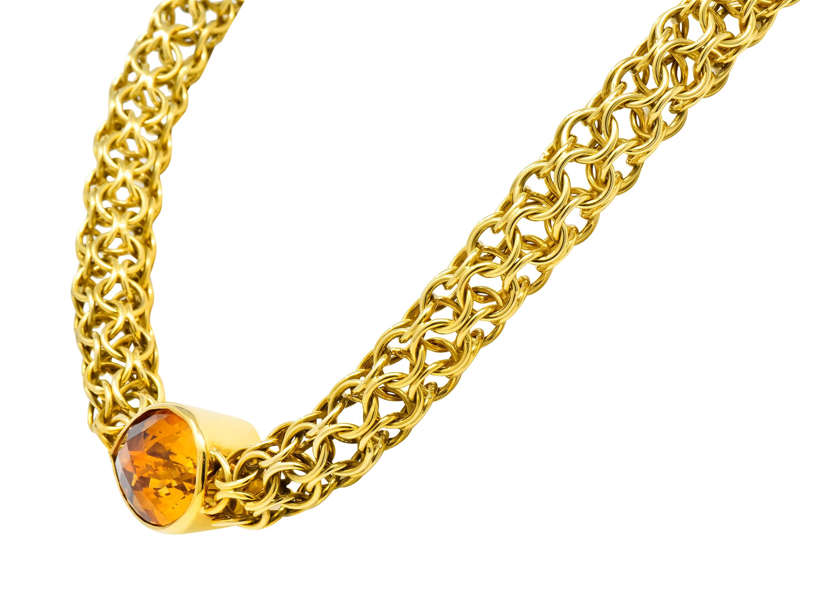 Centering a pear checkerboard mixed cut citrine measuring approximately 3/4 x 1 1/8 inches; transparent and a golden honey color

Bezel set in a polished gold surround flanked by tubular meshed chain comprised of round interconnected jump