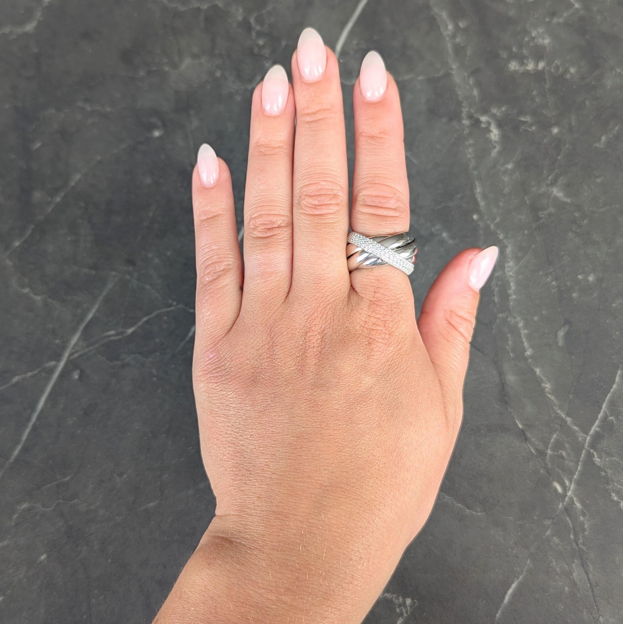 Ring is comprised of three interlocking white gold bands
One band is pavé set with round brilliant cut diamonds
Weighing approximately 0.80 carat total - G color with VS2 clarity
With high polished finish throughout
Stamped with for 18 karat