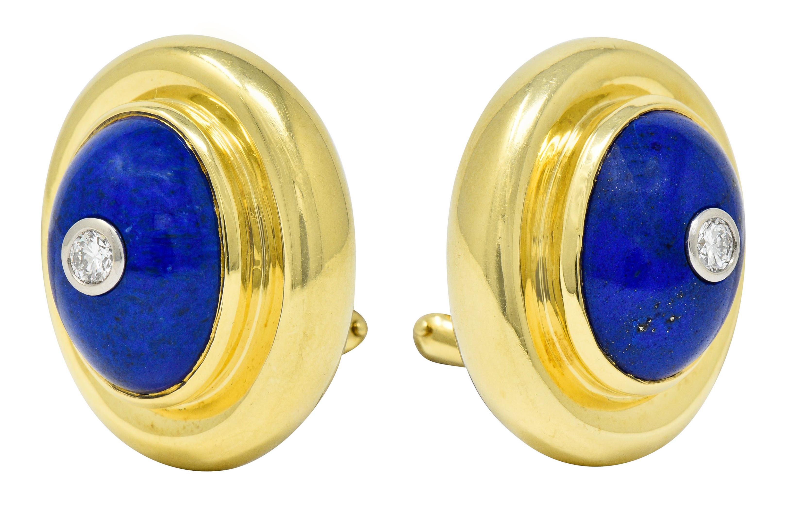 Each earring centers a round brilliant cut diamond with 0.30 carat total weight; F/G color and VS clarity

Bezel set low in an oval cabochon of lapis measuring approximately 15.0 x 11.0; uniform ultramarine color

Bezel set in a polished gold