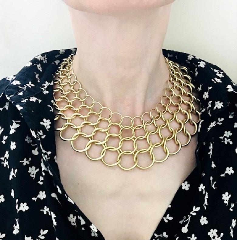 An exquisite 18k gold collar necklace designed by Paloma Picasso for Tiffany & Co. Its impressive vowed texture comes from connected gold circles that are graduated in sizes and thickness. Four rows of circles lay flat to create a collar that fits