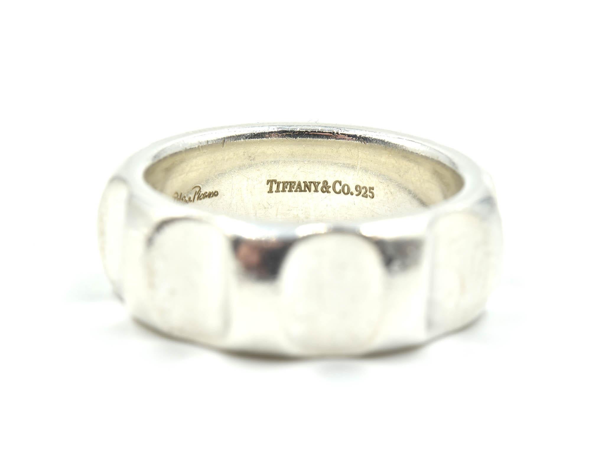 This is an awesome design by Tiffany & Co! Tiffany & Co made this gents wedding ring in high polished sterling silver with a cog shaped band! The band is size 10 ¼ the ring measures 8.47mm in length and 1.83mm in width at the shank. The wedding band