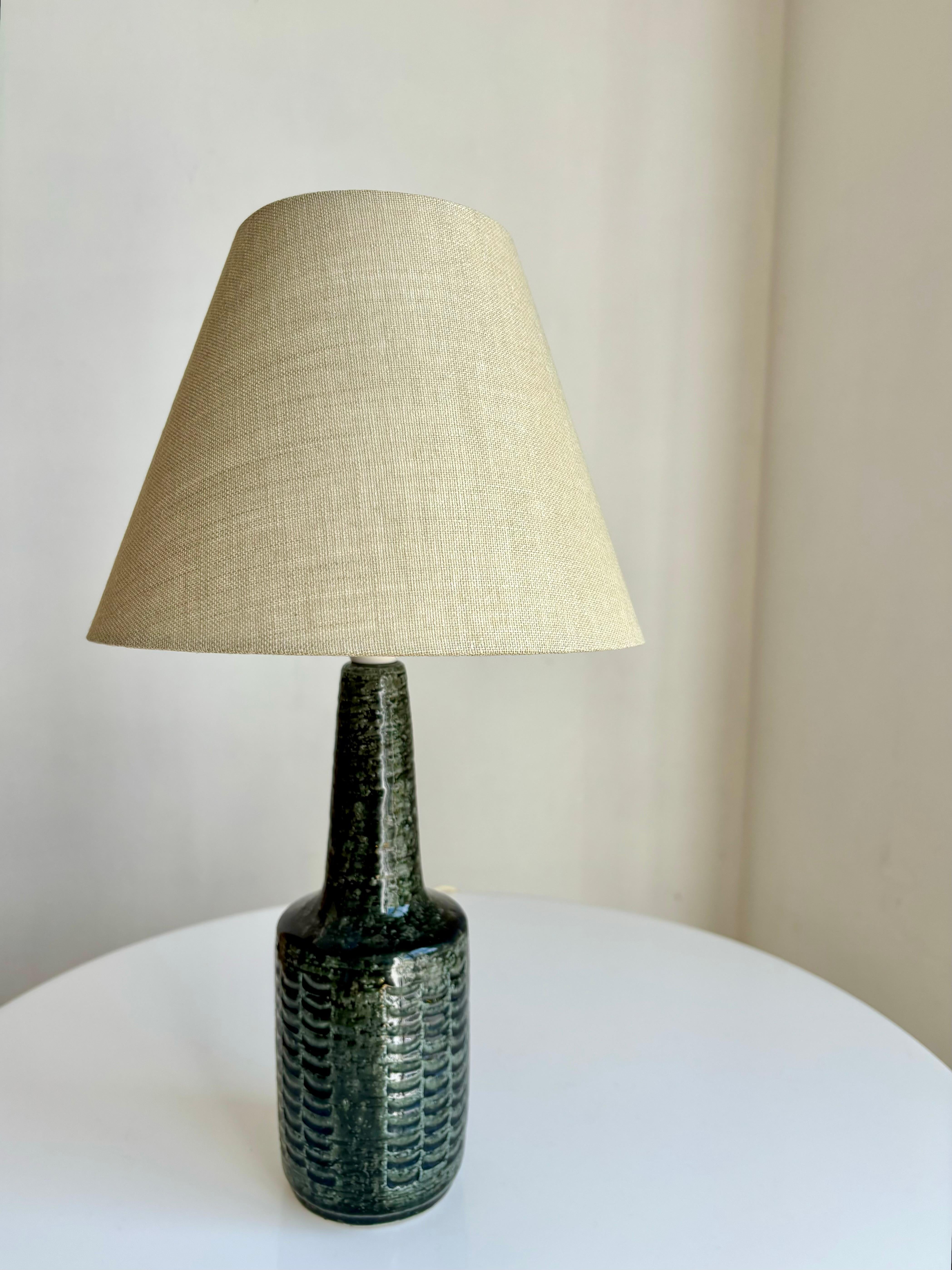 Sculpturale et élégante lampe de table en grès chamotté vintage, faite à la main par le studio d'art céramique Palshus. Conçu et fabriqué à la main par Per Linnemann-Schmidt dans les années 1950. Glaçure vert mousse sombre et brillante avec un