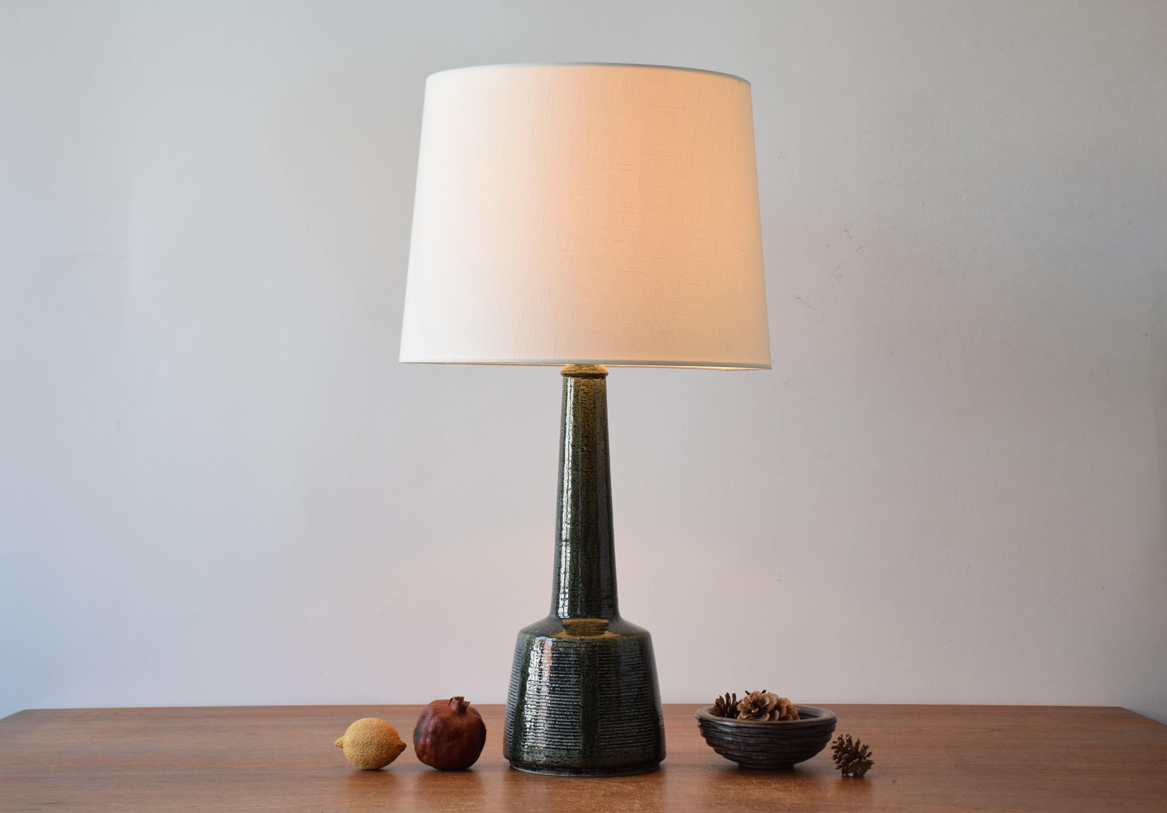 Vintage Palshus Denmark tall ceramic table lamp including new quality lampshade.

The lamp was made in cooperation with the Danish lamp manufacturer Le Klint and designed by Esben Klint. It was manufactured circa 1960s. The lamp has a bottle green