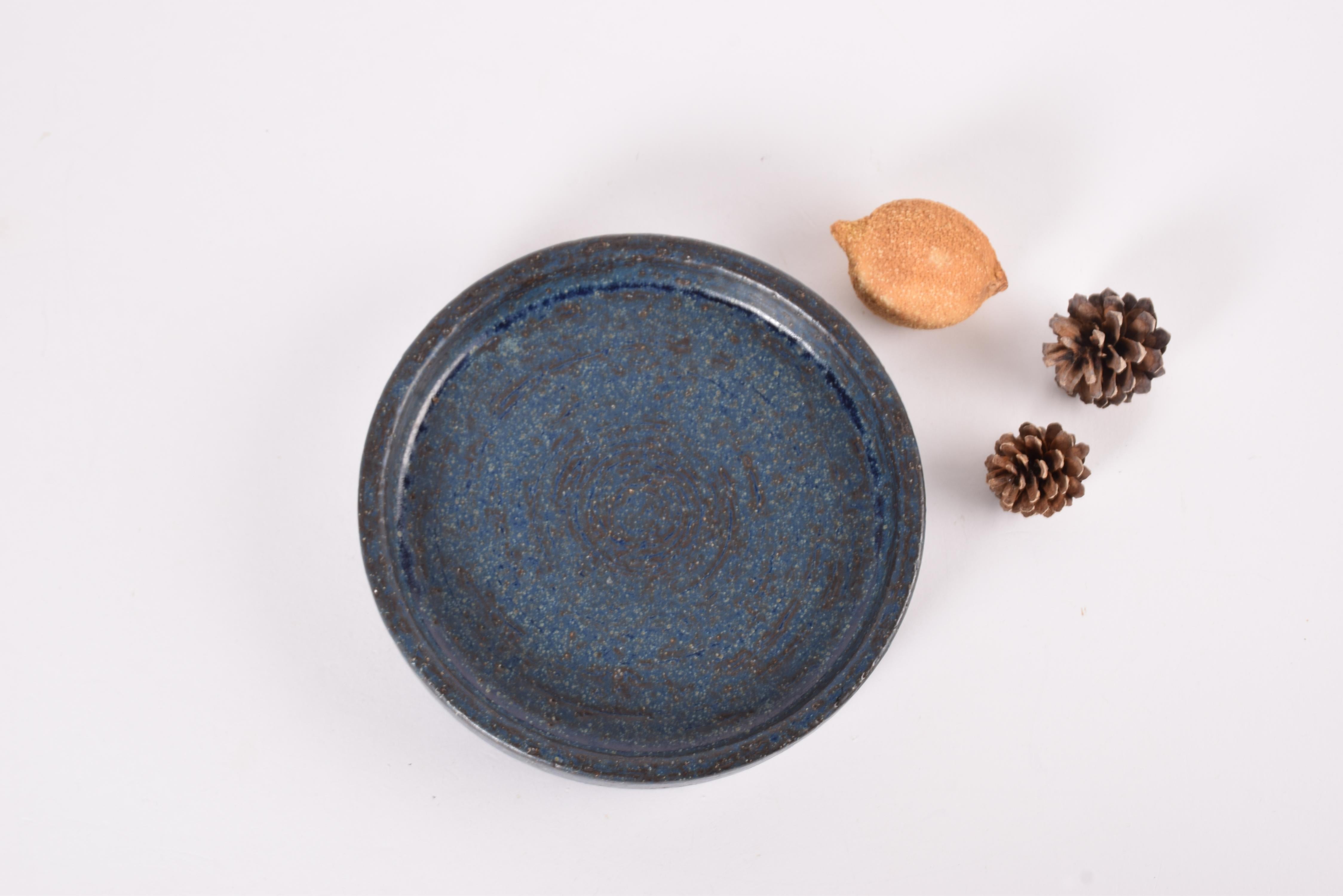 Low ceramic bowl by the acknowledged Danish ceramic workshop Palshus. It is designed by Per Linnemann-Schmidtand made in the 1960s or early 1970s.

The bowl is made from chamotte clay and has an interesting dark blue glaze with brown elements and