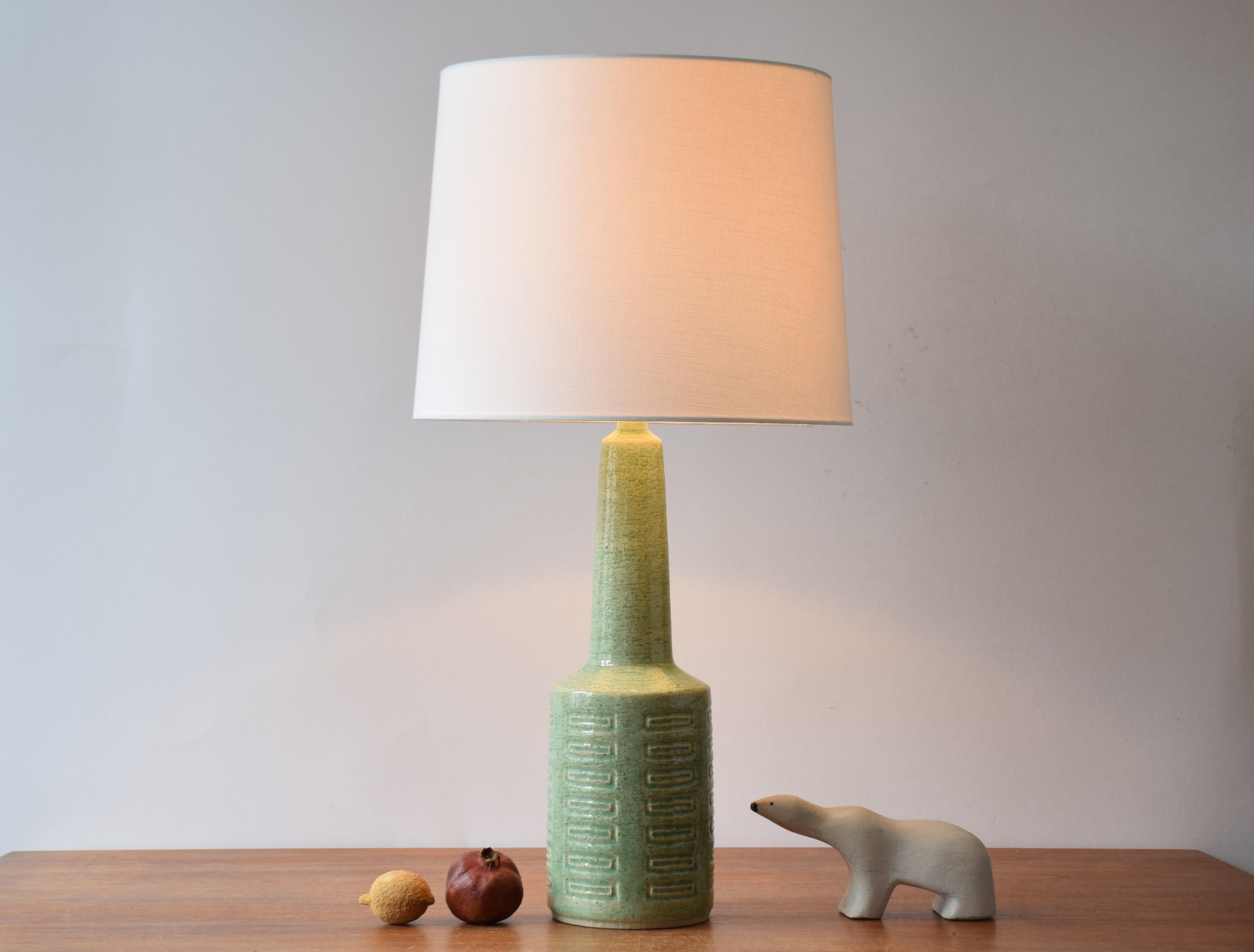 Tall Mid-century Danish ceramic table lamp from Palshus with pale green glaze.
The lamp was designed by Per Linnemann-Schmidt and manufactured in their own studio circa 1960s or early 1970s.
It is made with chamotte clay which gives a rough and