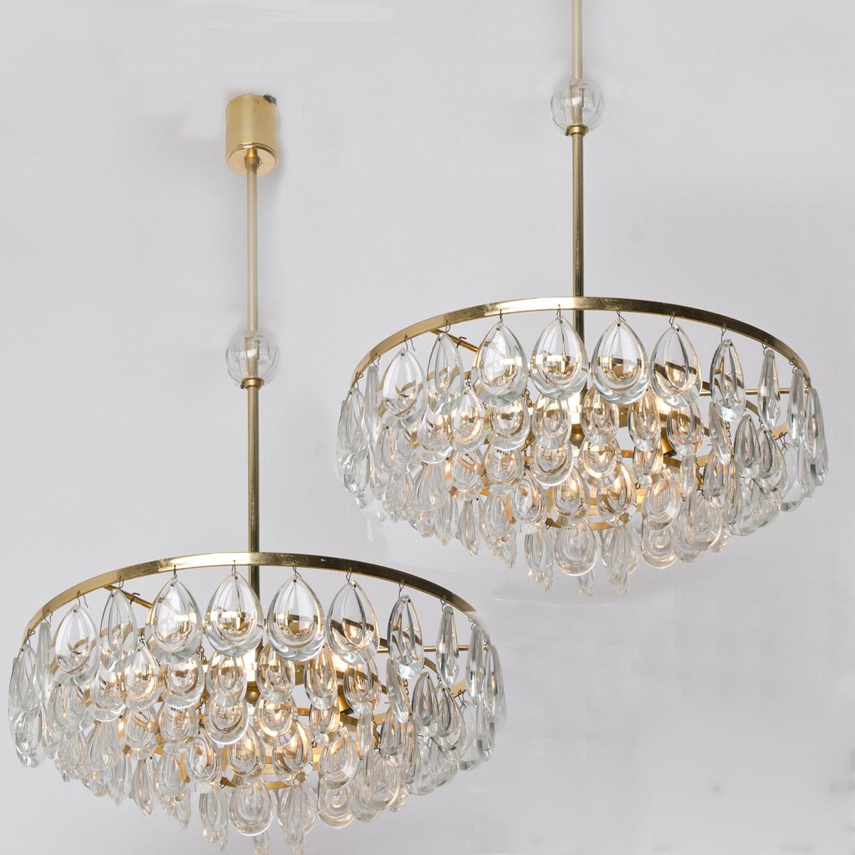 Wonderful pair of gilded brass and faceted crystal chandeliers by Palwa, Germany, manufactured in midcentury. Minimalistic design executed with a taste for excellence in craftsmanship. The glass bulb on the rod can be removed if