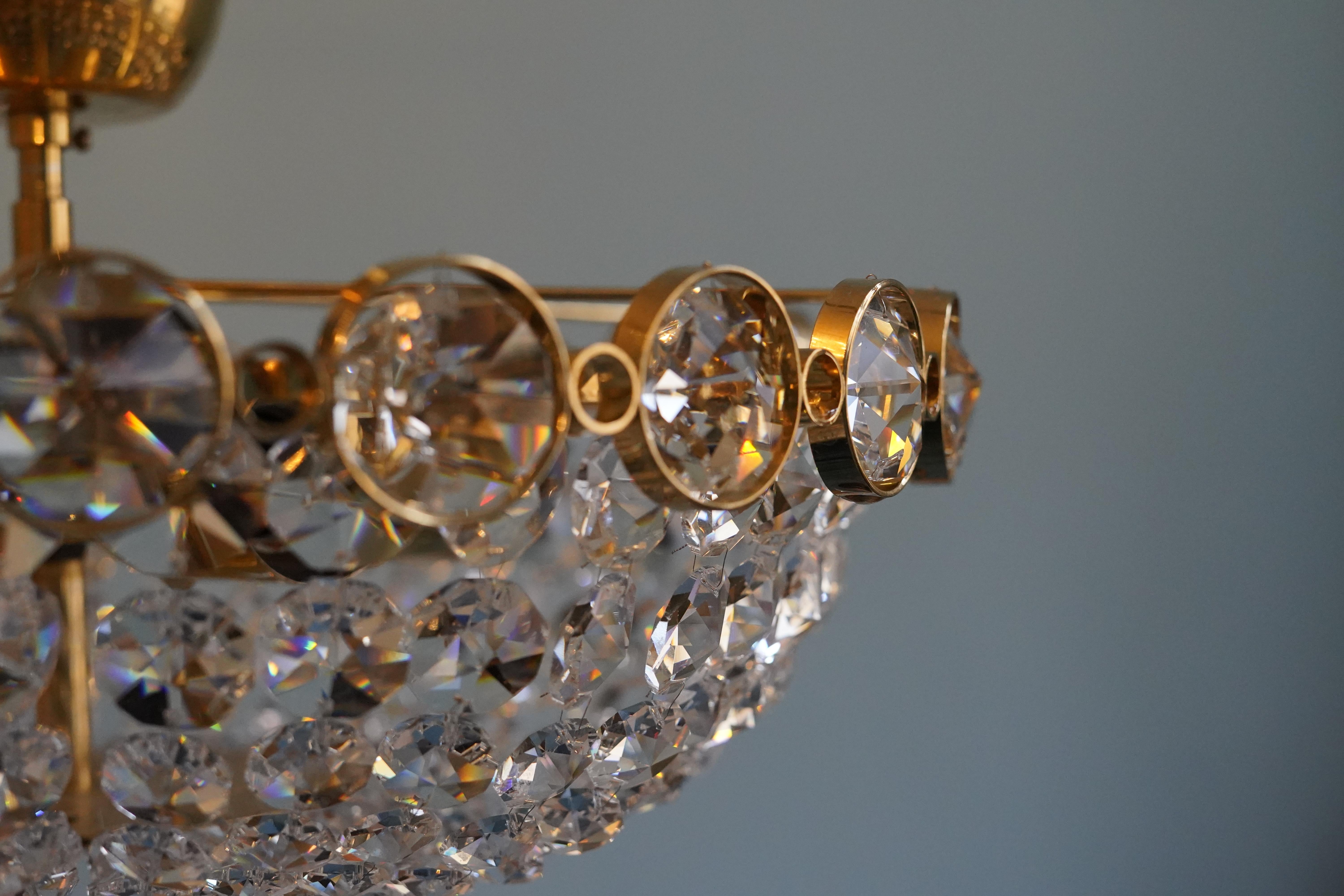 Chandelier ,chunky diamond cut crystal in various sizes on a gilt brass frame By Palwa, Austria, 1970.
Highly saturated frame with various sized crystals cut in an octagonal shape surrounding the bottom which is a high polished round flat brass