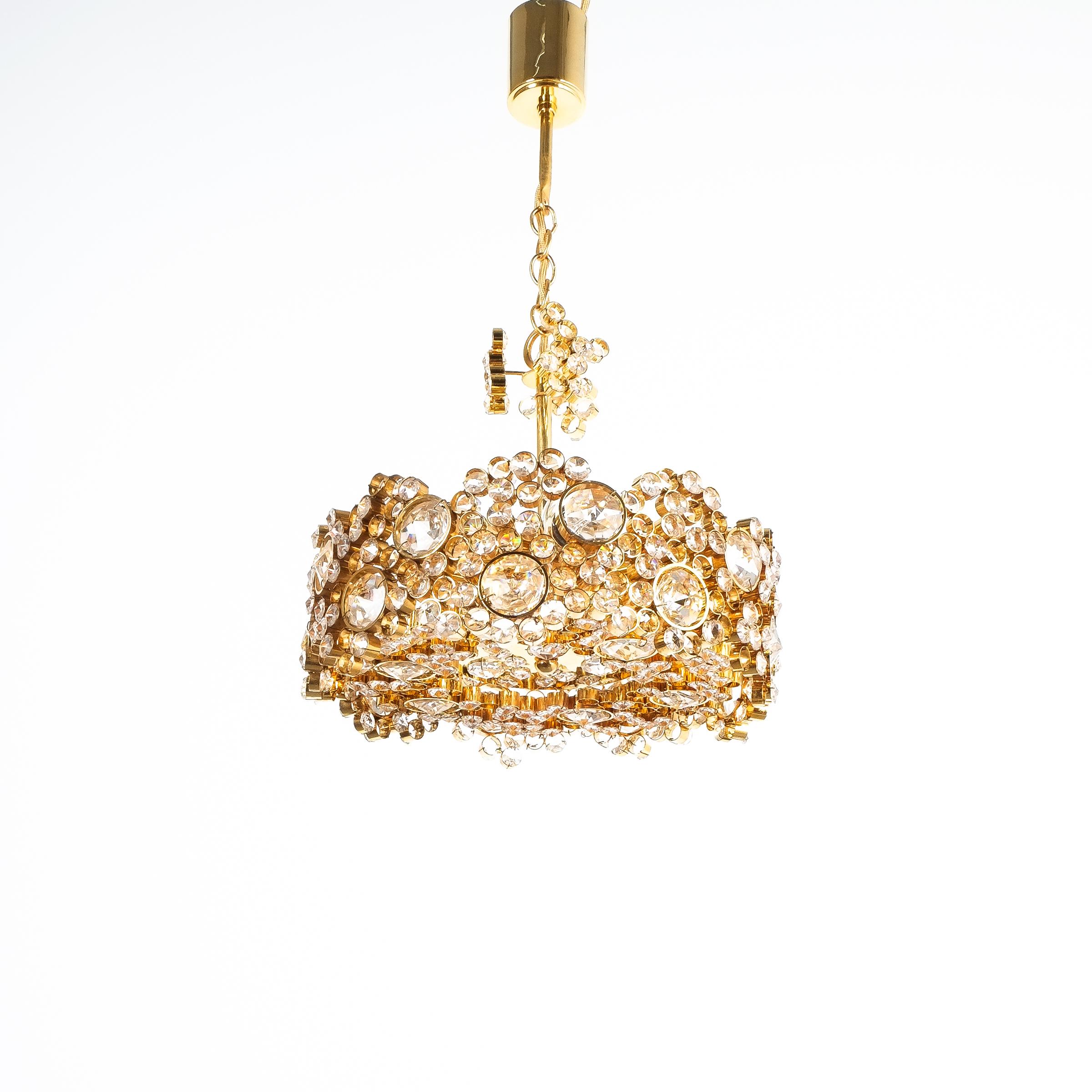 Petite Palwa Crystal glass gold-plated brass chandelier refurbished lamp, circa 1965. This lamp was handcrafted and executed with great attention to detail, consisting of hundreds of gilded brass rings encrusted with crystal glass varying in size.