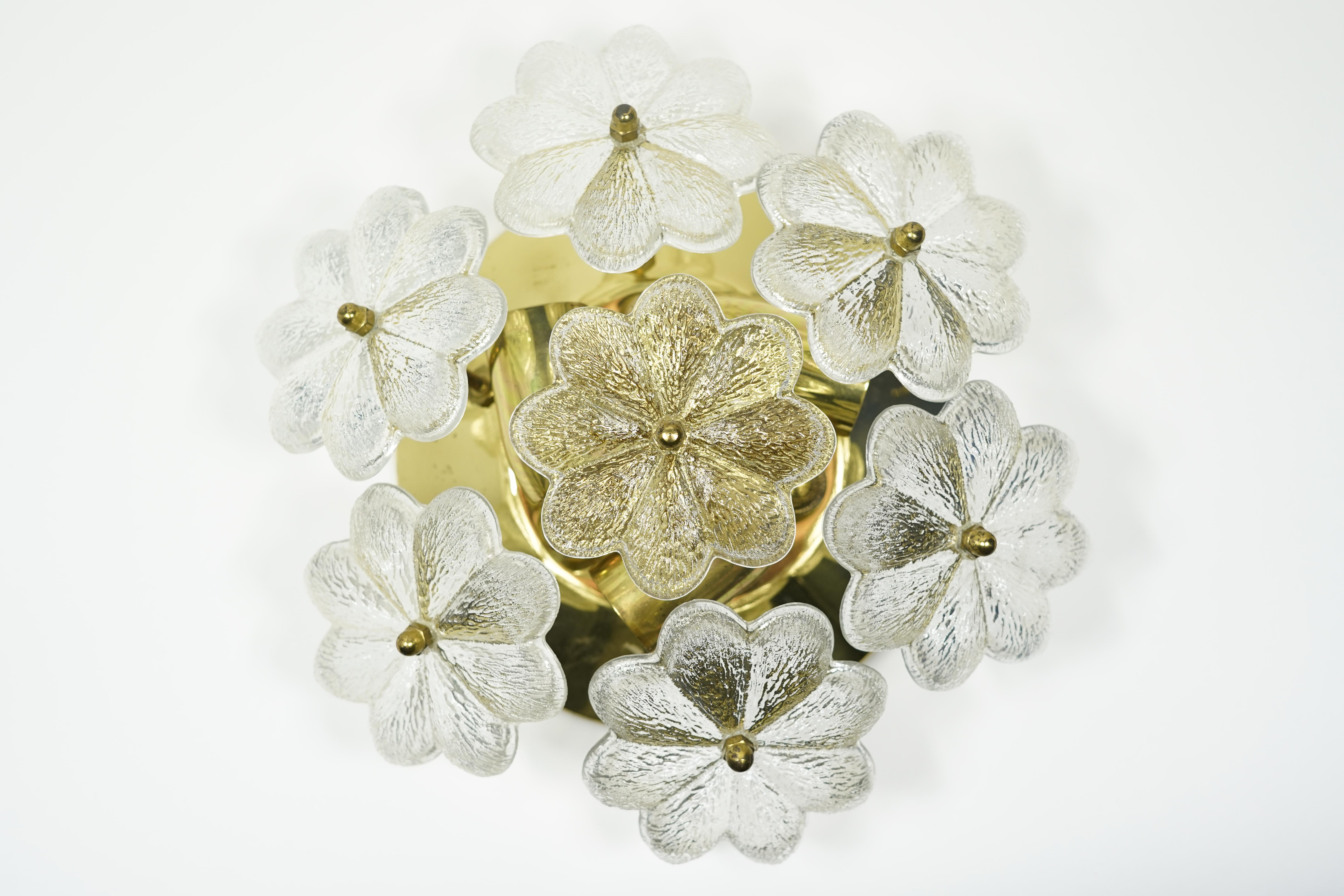Base en laiton poli avec 3 douilles de candélabre, 7 pièces de verre individuelles maintenues par des fleurons en laiton.  en forme de fleur forme une ombre.