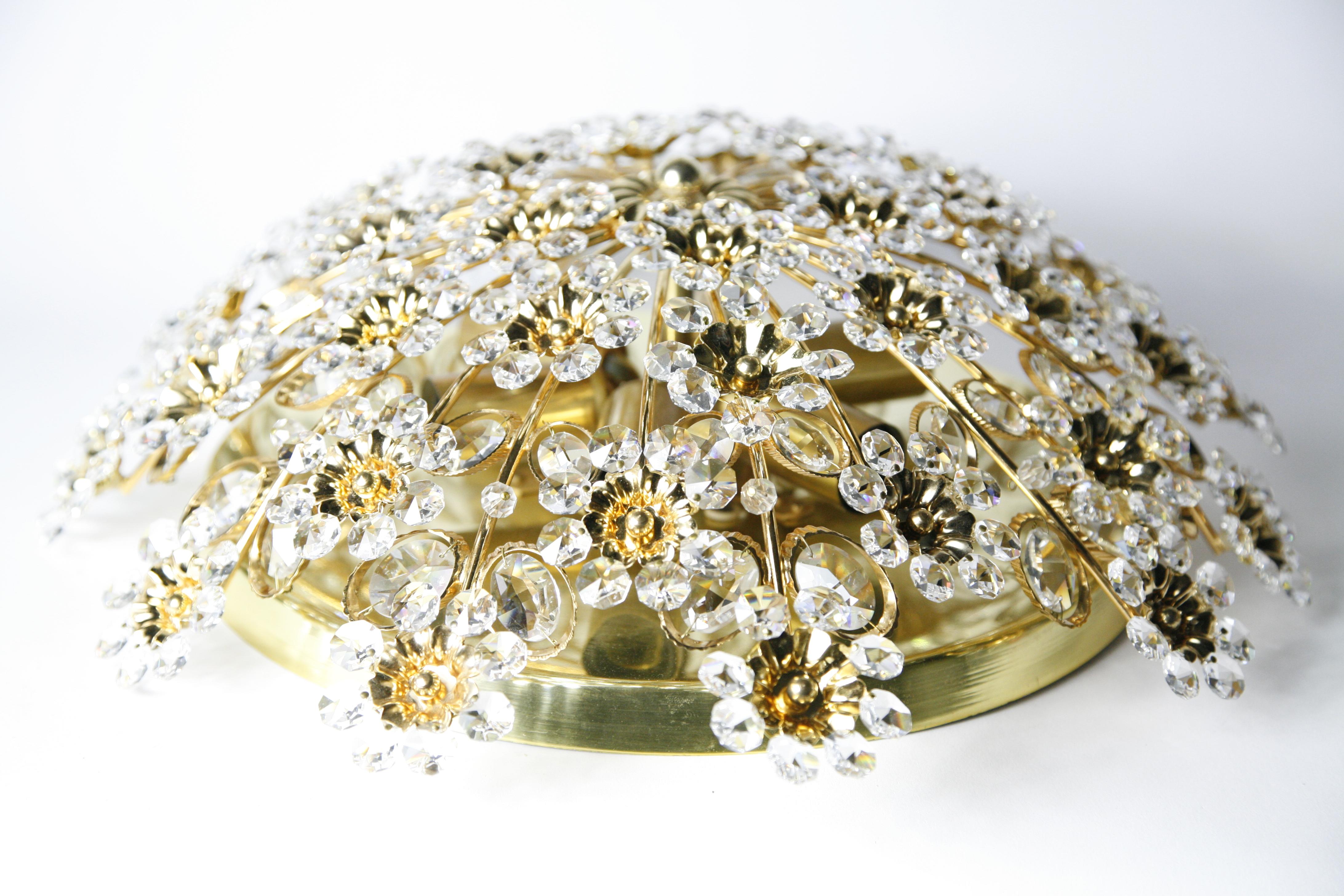 1970er Jahre runde Unterputzmontage  vergoldeter Rahmen mit zahlreichen geschliffenen Kristallen und Perlen in verschiedenen Größen, die in Form von Blumen angeordnet sind, Österreich.
Sechs europäische Kandelaberfassungen.

Signiert und nummeriert