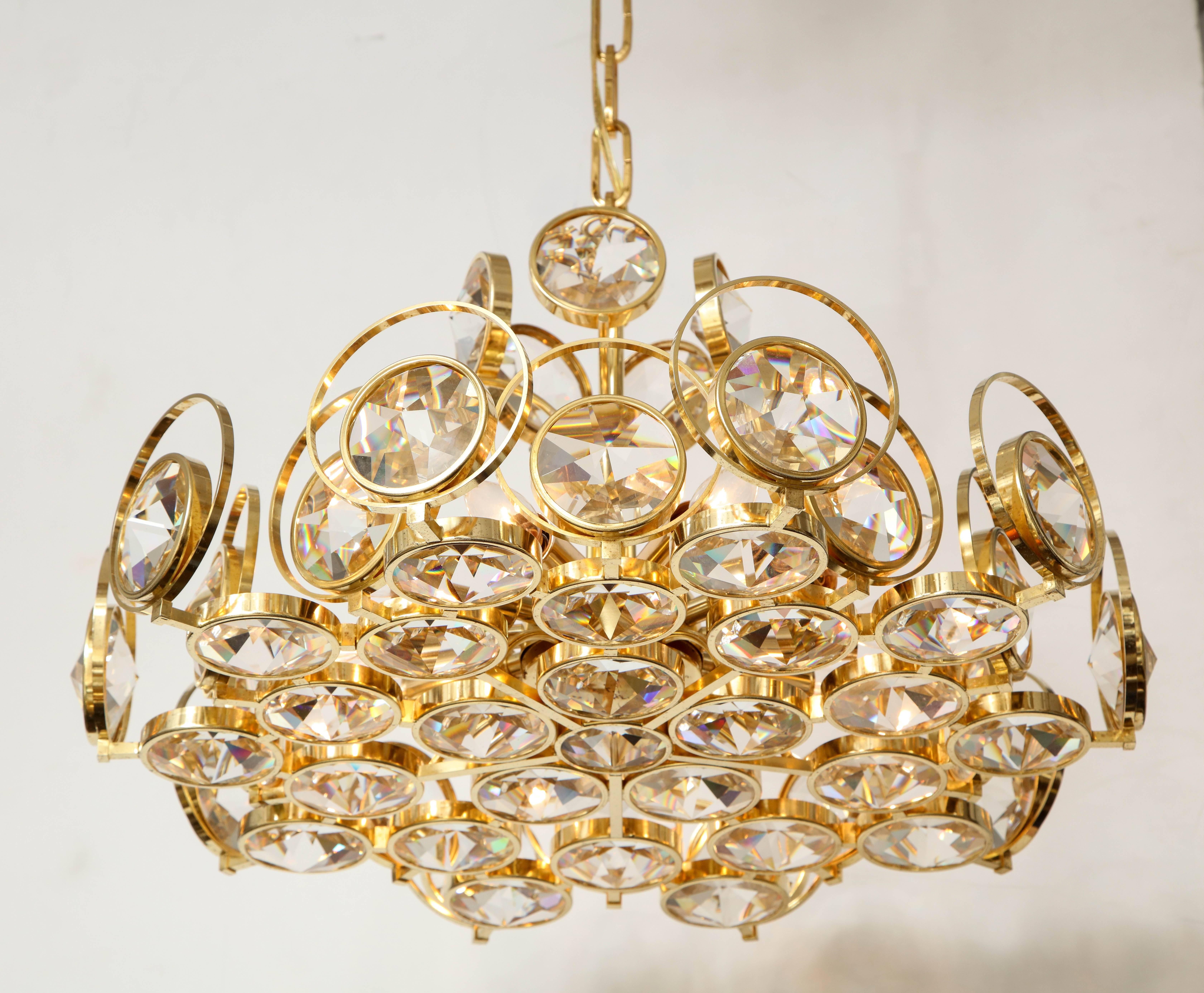 Superbe lustre Palwa Hollywood Regency avec un cadre et une chaîne en laiton doré 22 carats avec des embellissements en cristal facetté suspendus à l'intérieur du cadre par Palwa. Recâblé pour une utilisation aux Etats-Unis, le luminaire dispose de