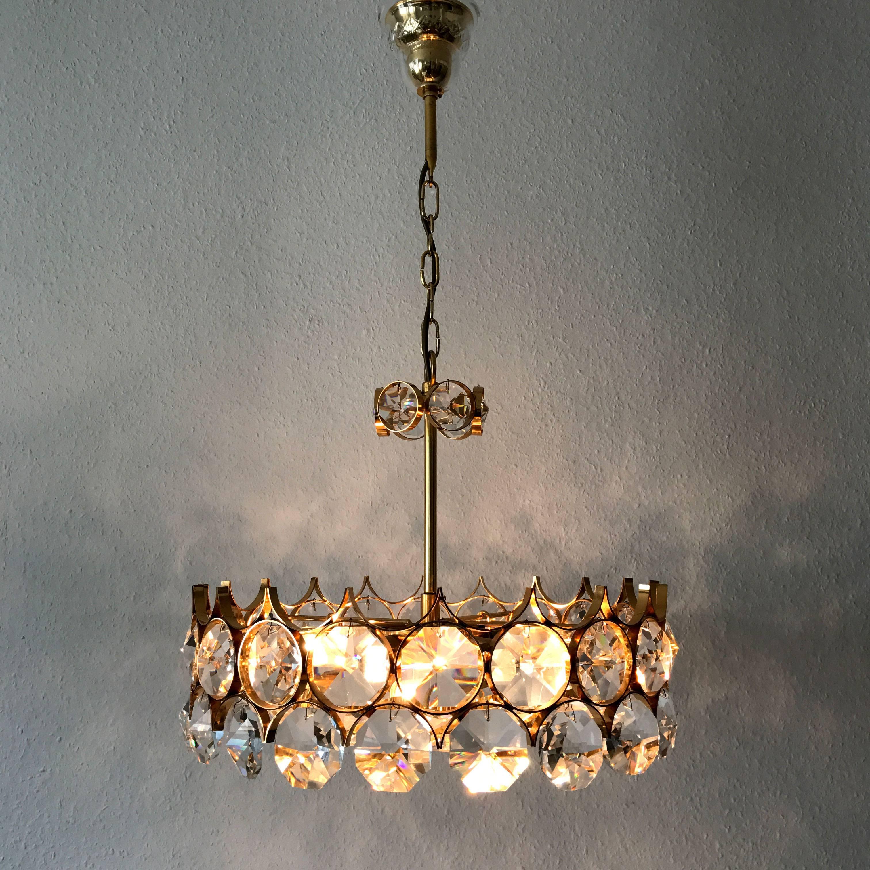 Awesome Mid Century Modern chandelier or pendant lamp with large facet cut crystal glass elements and gilt brass frame. Designed and manufactured by Palwa, Germany, 1960s-1970s. 

Executed in crystal glass and gilt brass, The chandelier needs 6 x