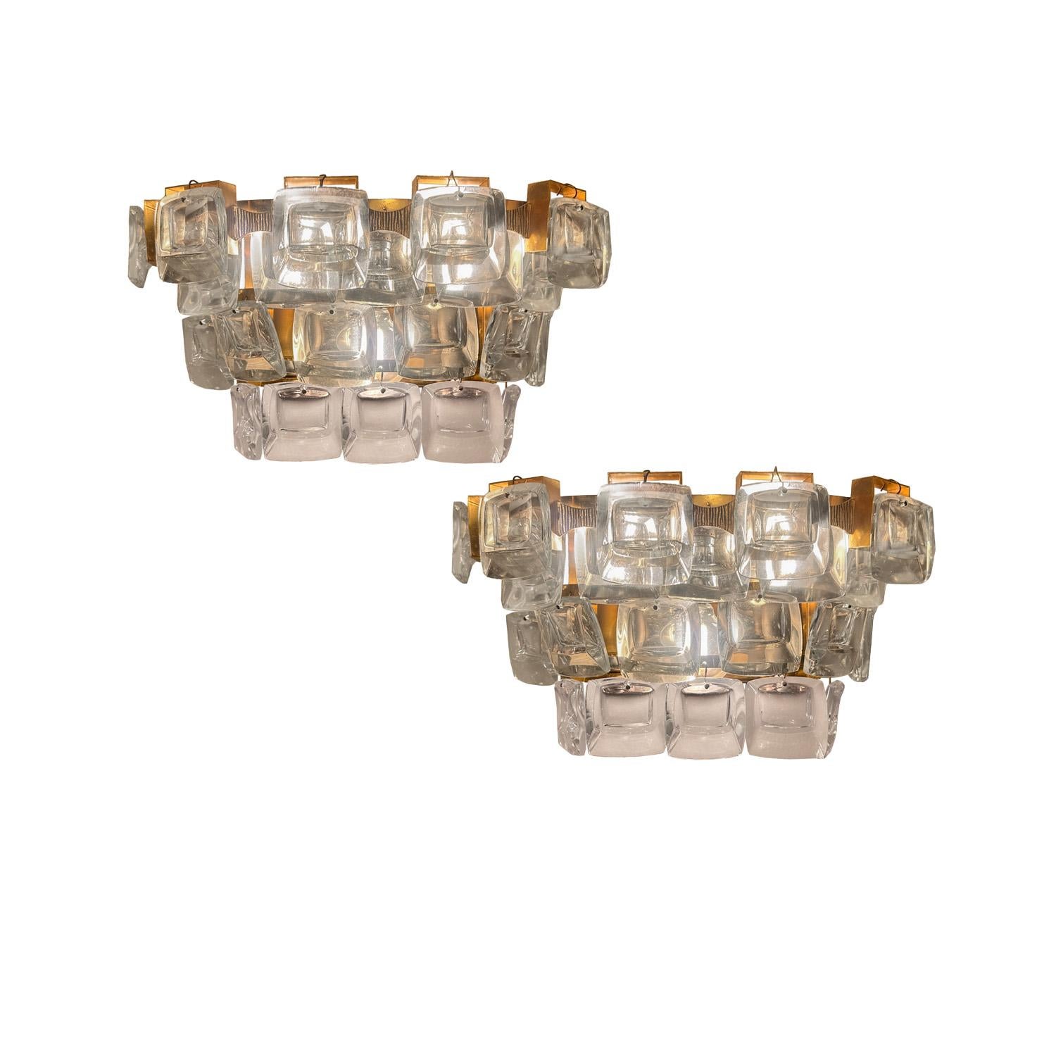 Irregular square crystals  evoke small televisions screens hanging in tiered formation on  golden etched brass frames on this pair of Mid-Century Modern style sconces.  A unique modern interpretation of the classic crystal sconce by the German