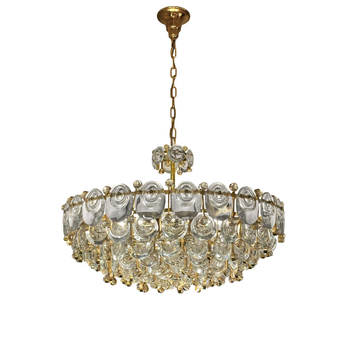 Abbaglianti livelli concentrici di gocce e bastoni di cristallo concavi con perle di cristallo sfaccettato rivestono un  cornice in ottone dorato a cascata. Elegante e illuminante, questo lampadario è adatto ai reali ed è un ottimo esempio