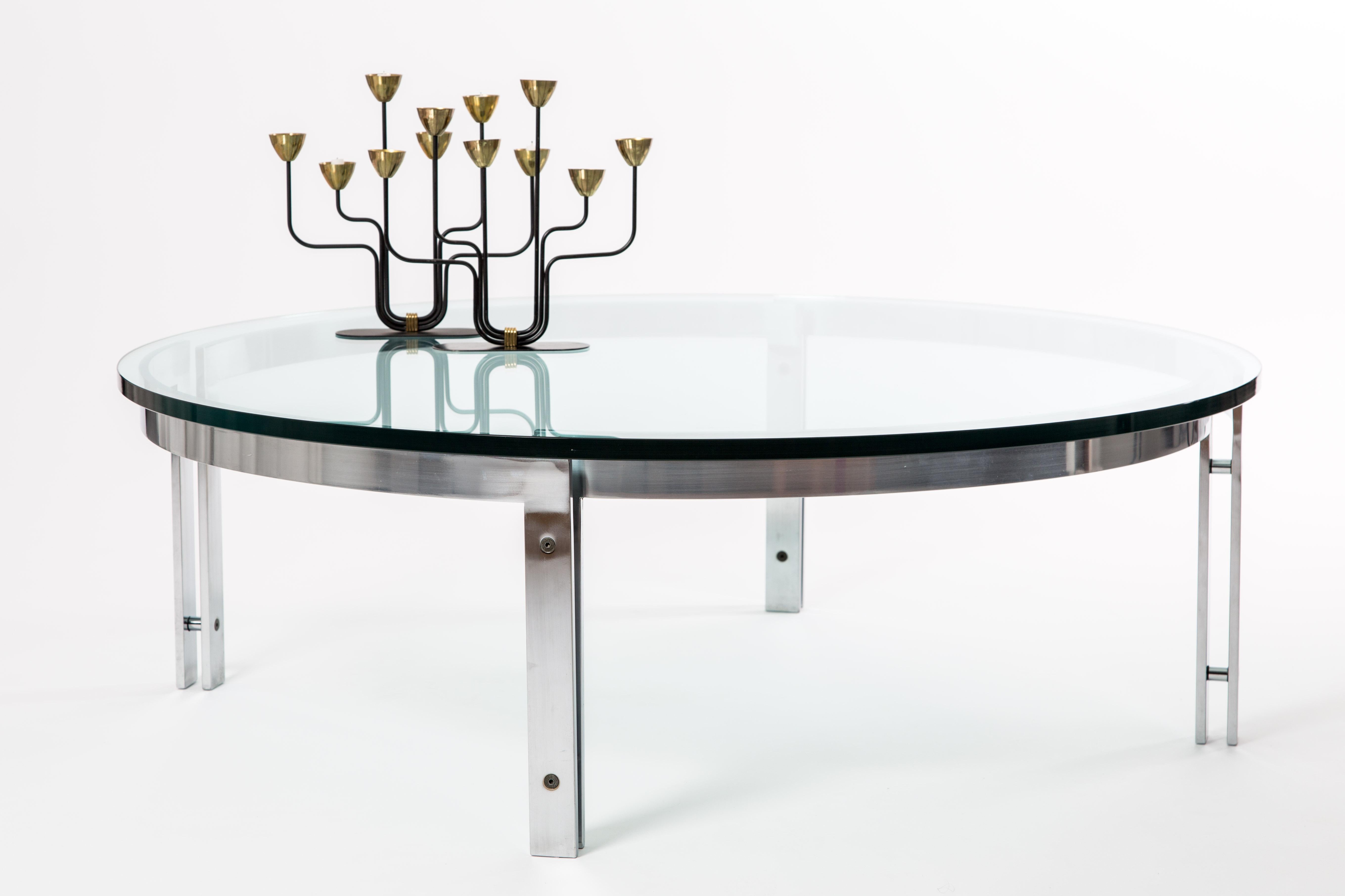 Metaform round glass table. Heavy solid top of 19 mm glass. Stainless steel frame with socket screws. High-tech construction.