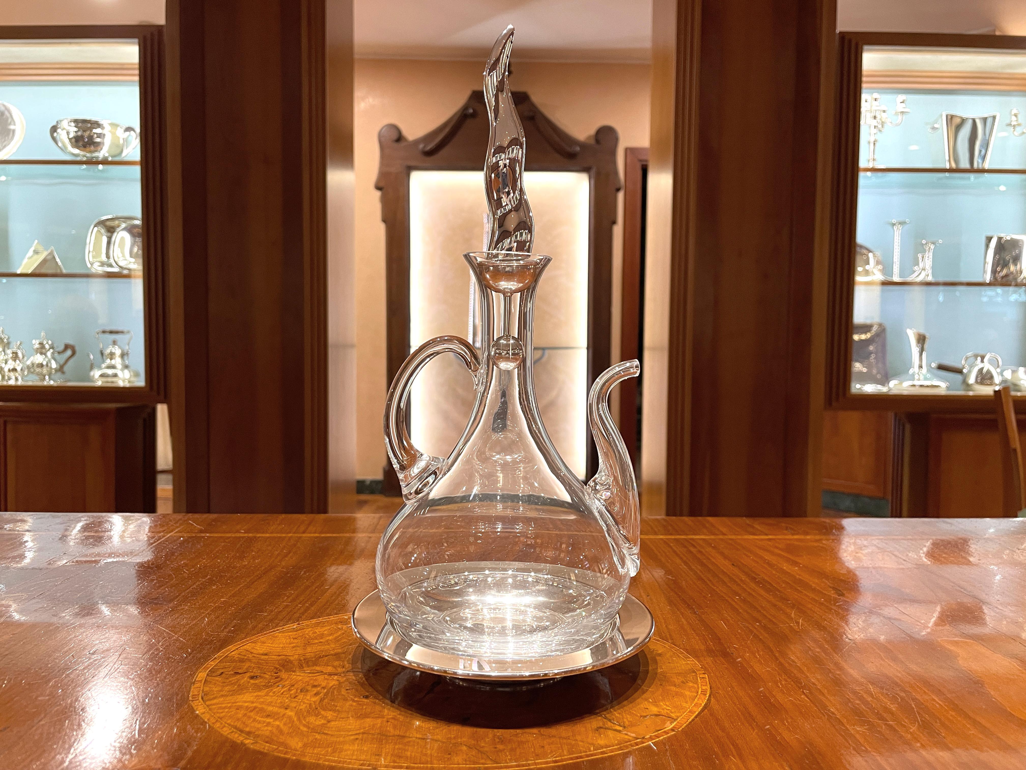 Oliera in cristallo con piatto e tappo in argento sterling 925/ooo. 
Il tappo è un contenitore per sale, pepe, peperoncino o qualsiasi altra spezia preferita

Peso complessivo 680 g, peso degli elementi in argento 136 g.
Altezza totale cm 32,