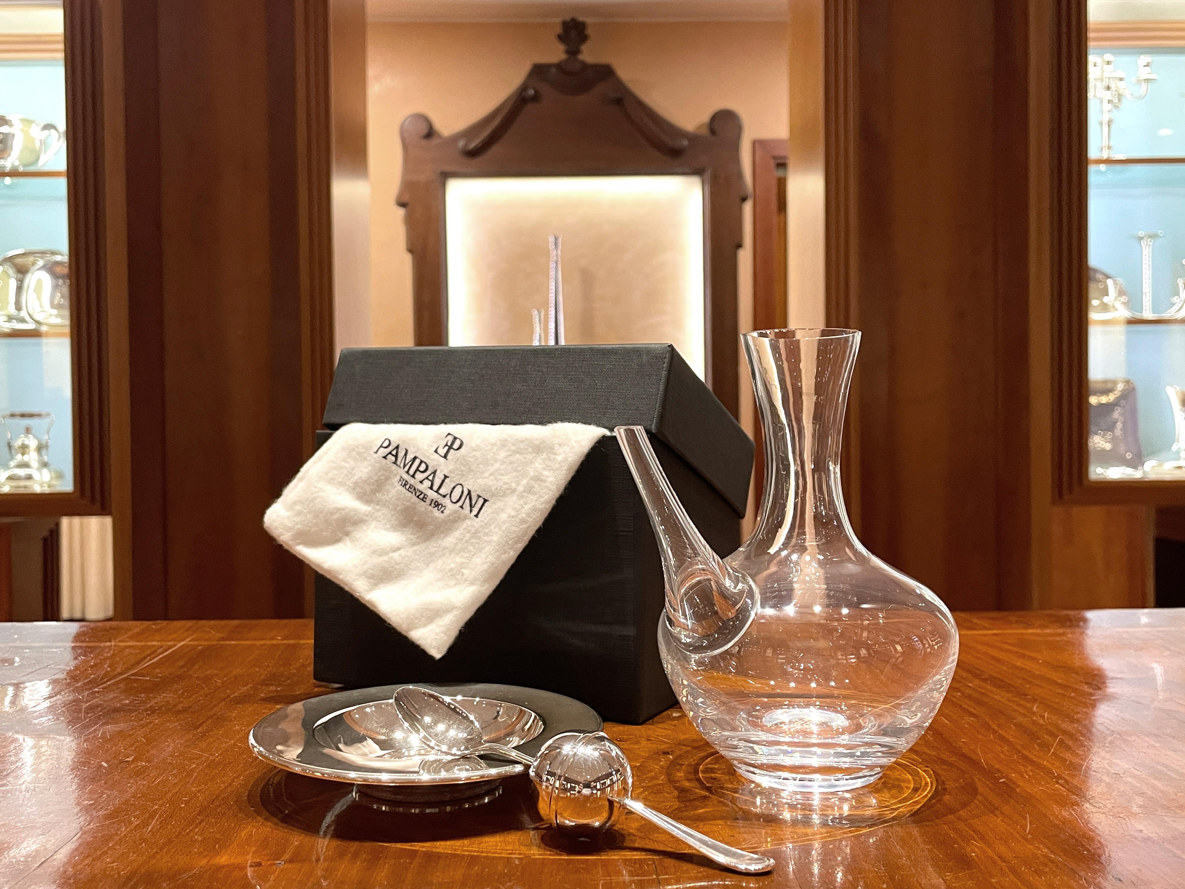 Oliera in cristallo con piatto e tappo in argento sterling 925/ooo. 
Il tappo cucchiaino è un contenitore per sale, pepe, peperoncino o qualsiasi altra spezia preferita

Peso complessivo 430 g, peso degli elementi in argento 96 g.
Altezza totale cm