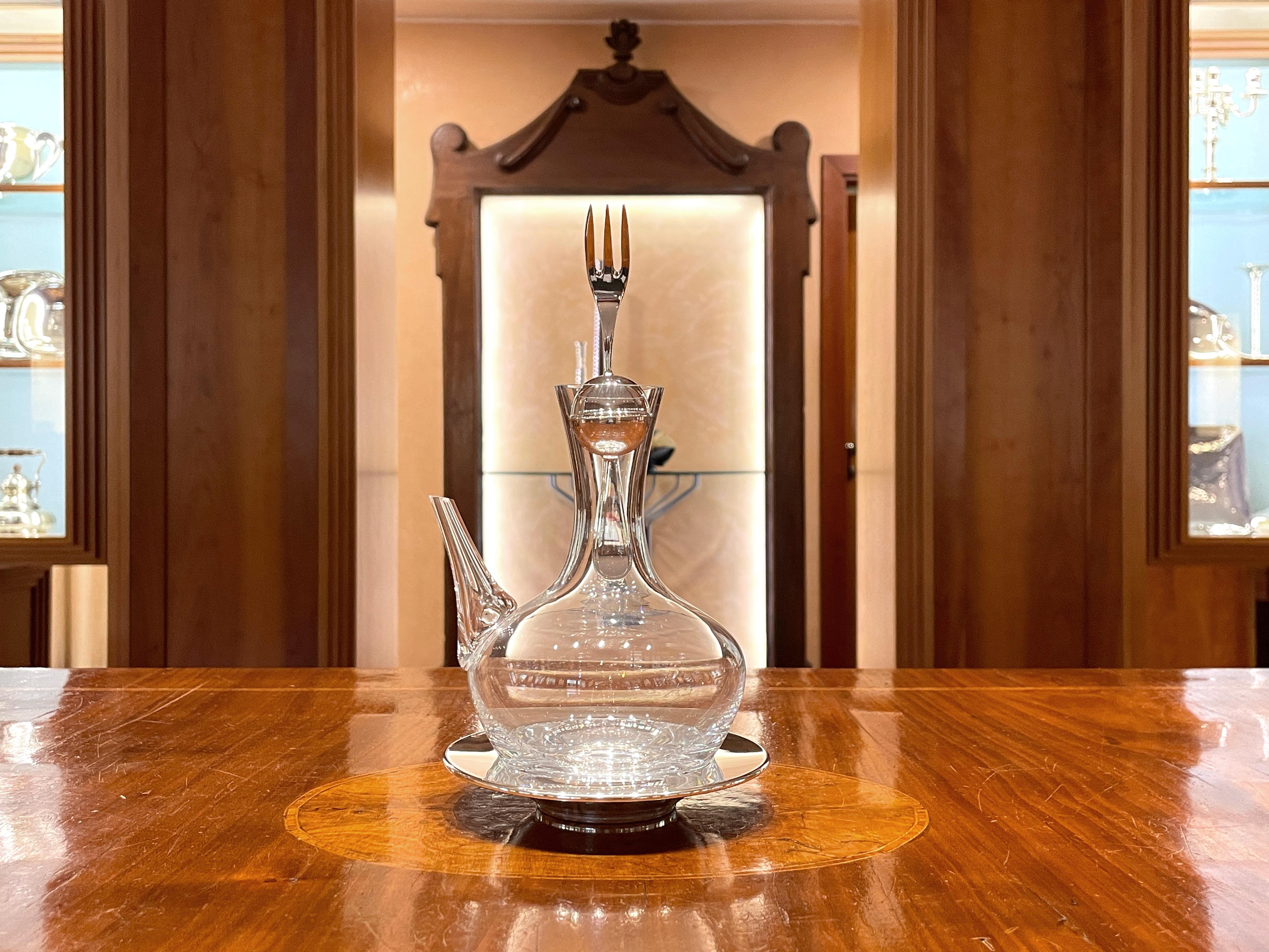Oliera in cristallo con piatto e tappo in argento sterling 925/ooo. 
Il tappo forchetta è un contenitore per sale, pepe, peperoncino o qualsiasi altra spezia preferita

Peso complessivo 430 g, peso degli elementi in argento 100 g.
Altezza totale cm