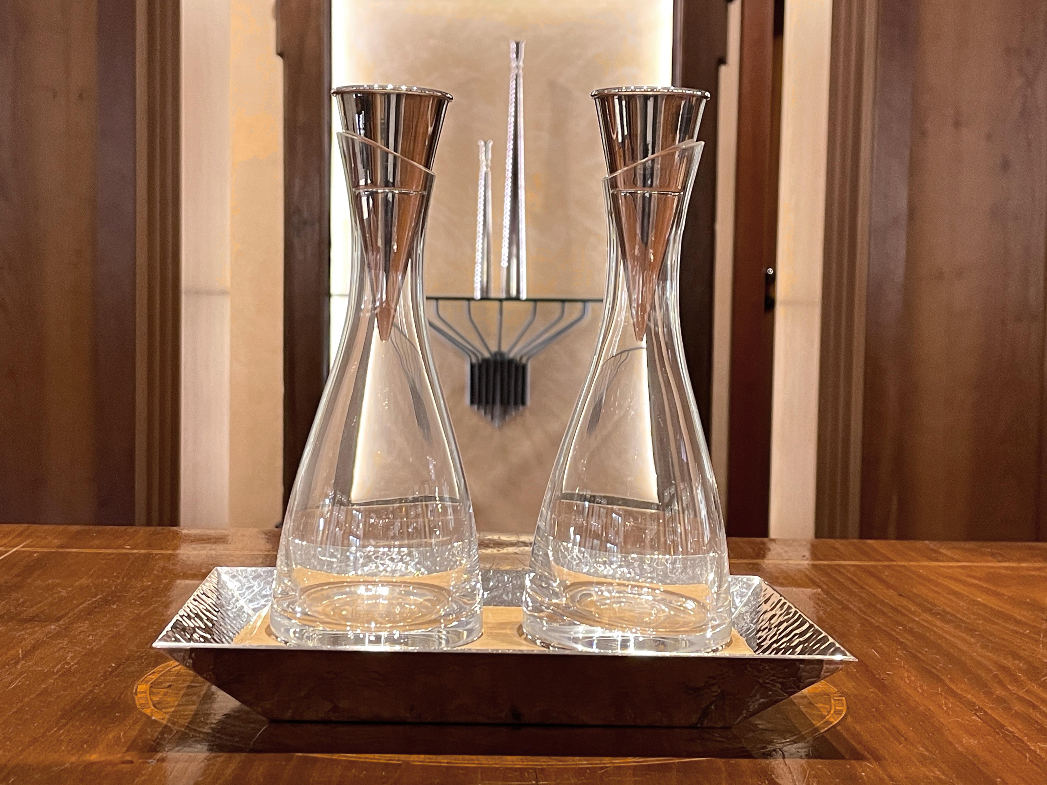 Set olio e aceto in cristallo con base in argento placcato e legno. I tappi delle due bottiglie fanno da contenitore di sale e pepe ed hanno una finitura lucida; si dividono a metà e la parte più grande fa da recipiente protetto ermeticamente da
