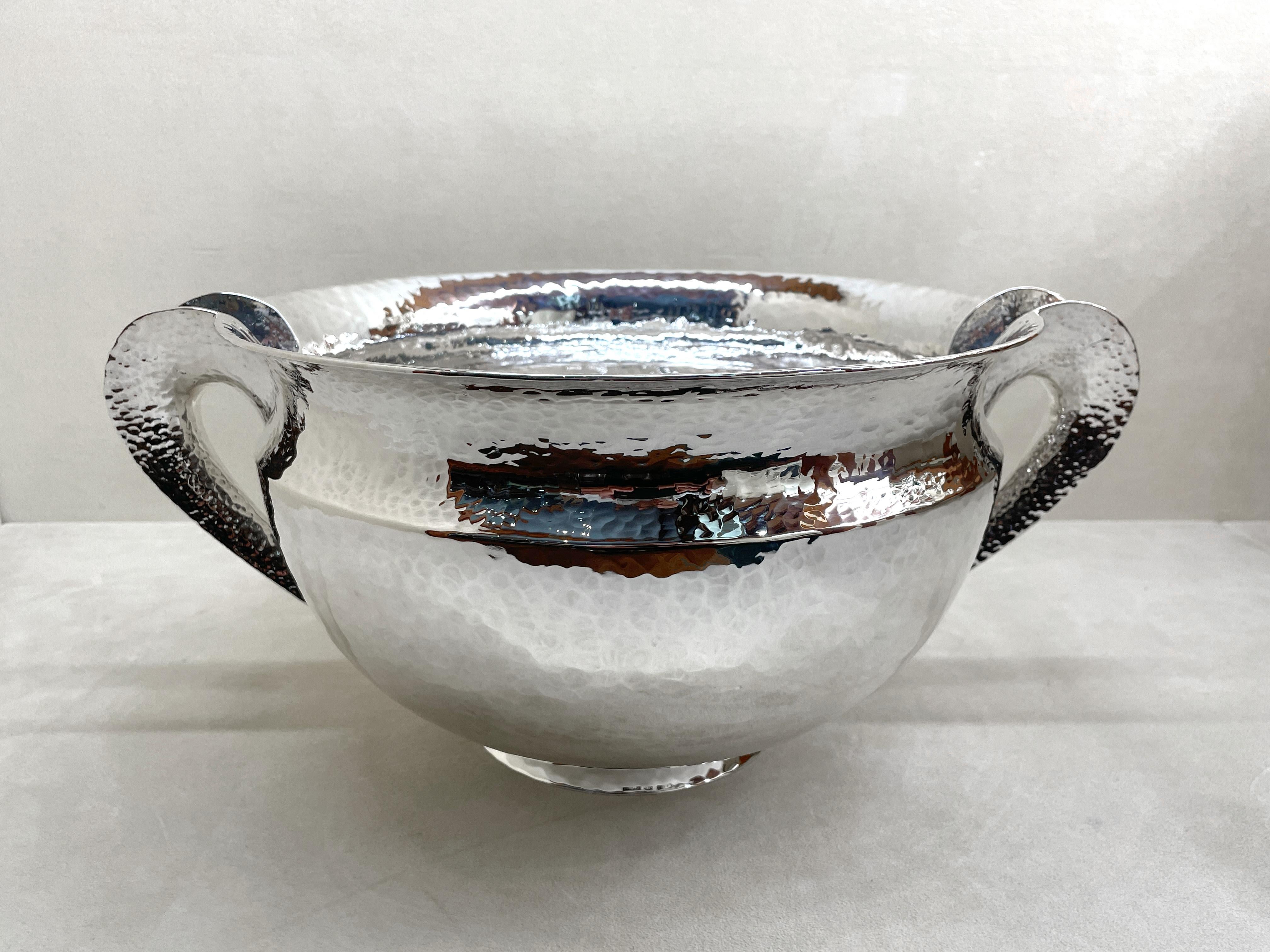 Vaso grande in argento 925/ooo, collezione Troia, prodotto da Pampaloni Firenze Italia. Peso g 2160, diametro cm 29,5, incluso i manici cm 38, altezza cm 17,5, diametro base cm 13.
Superficie martellata con finitura lucida
Utilizzabile anche come
