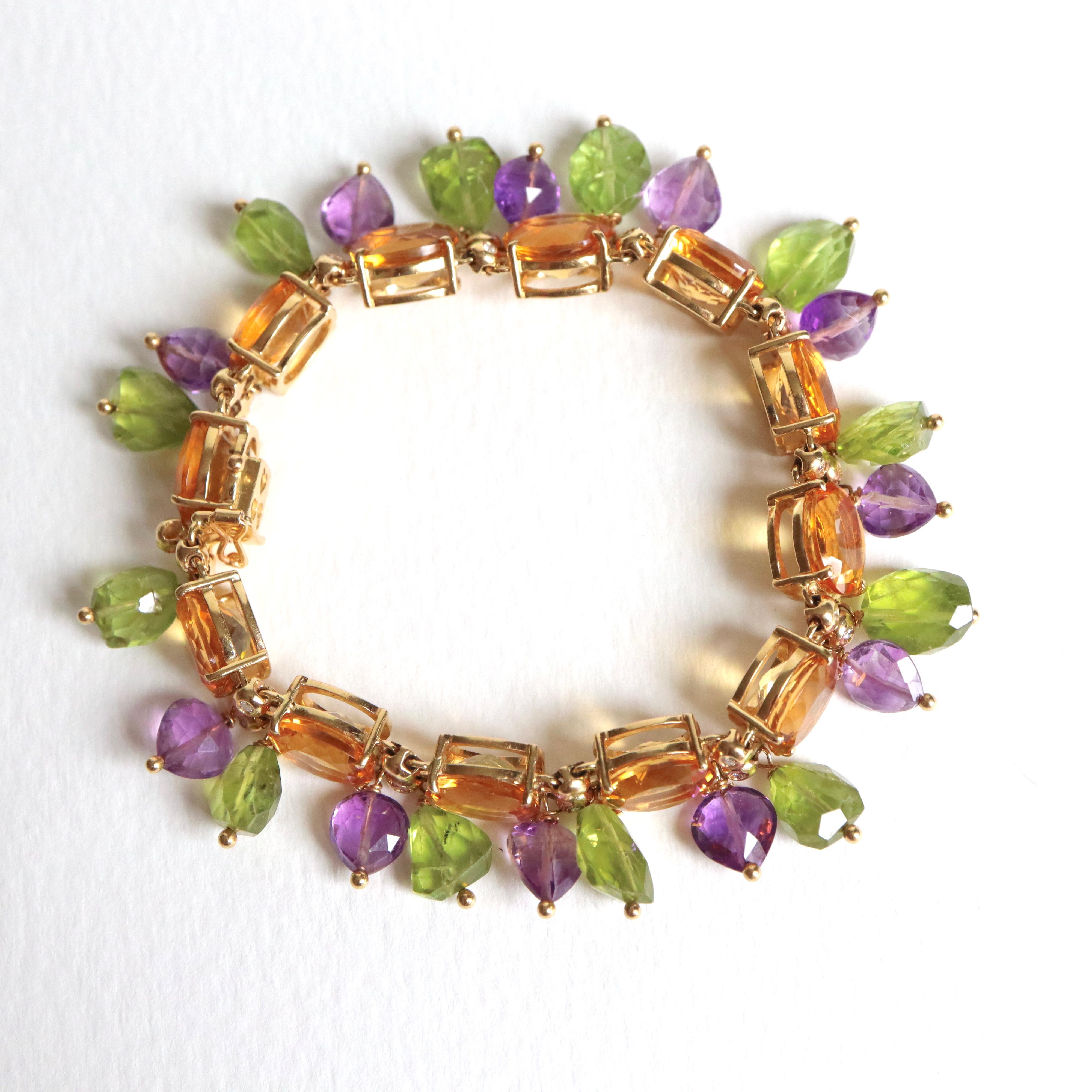 Pampilles Armband aus Gelbgold 18 Karat Citrin Peridot Amethyst und Diamanten
Das Armband besteht aus 12 großen Citrin (Länge 1 cm Breite 0,8cm) abwechselnd zwei kleine Diamanten geschlossen halten Briolette Größe Anhänger abwechselnd 12 Peridots