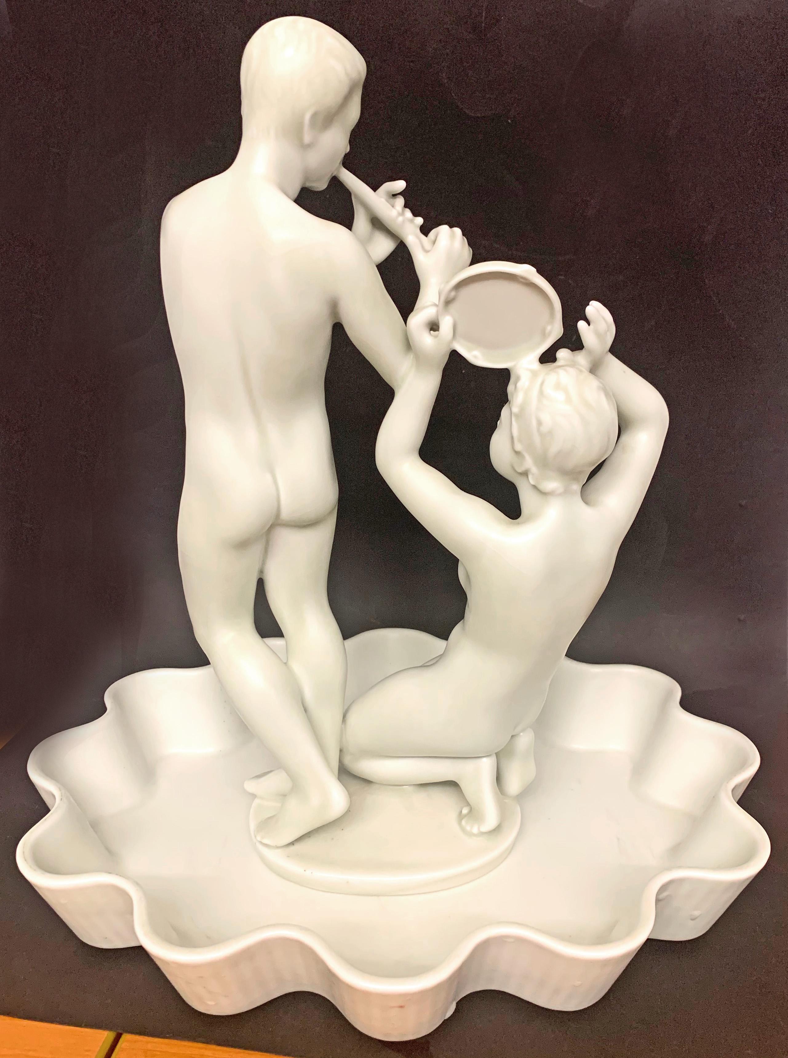 Diese anspruchsvolle und seltene Skulpturengruppe eines Pan und einer Nymphe mit Flöte und Zimbel wurde von Harald Salomon für die berühmte schwedische Porzellanmanufaktur Rörstrand entworfen und mit einer elfenbeinfarbenen Glasur versehen. Salomon