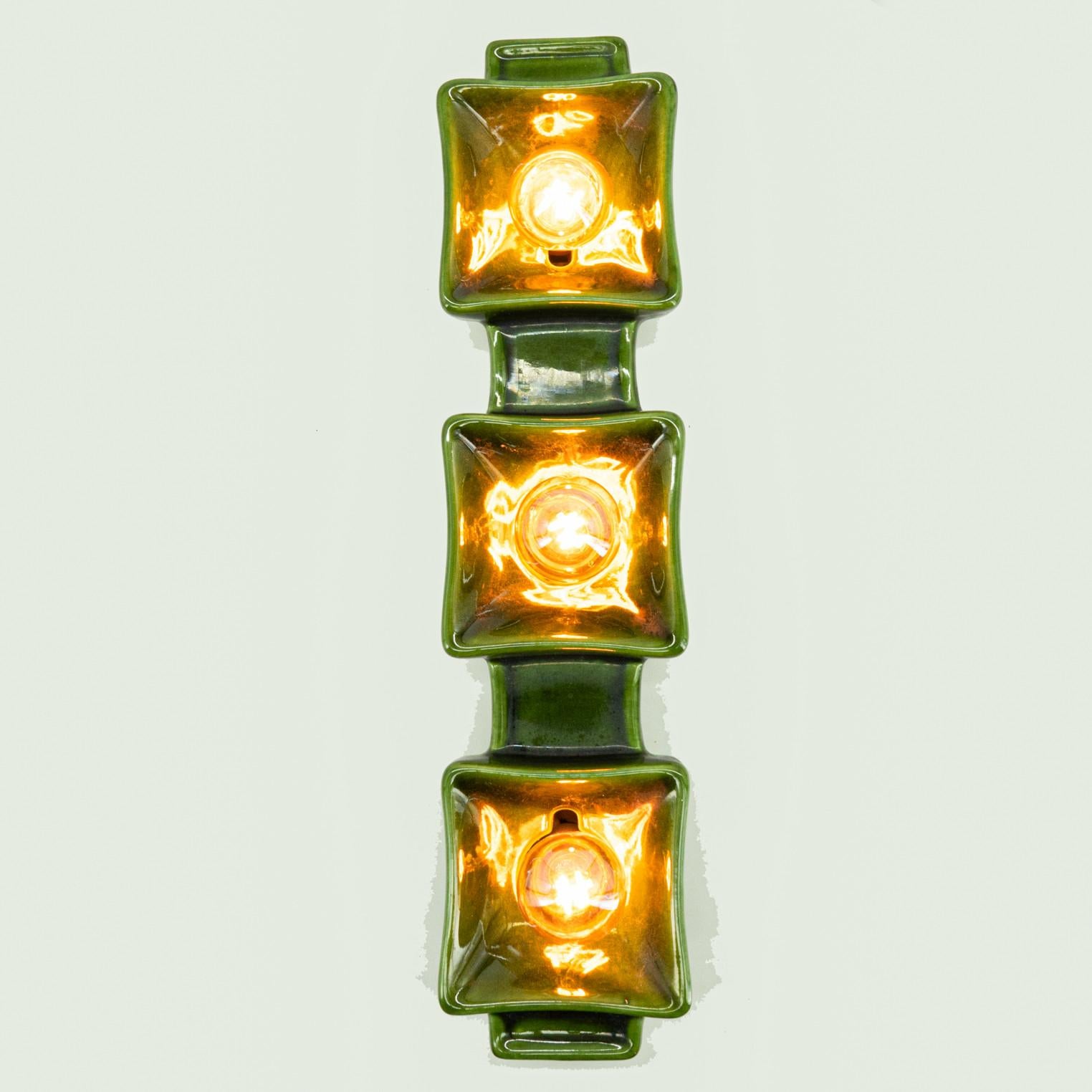 Green textured ceramic wall light, manufactured by Pan Ceramics in the 1960s. This lamp is a blend of playful and sleek design, making it a bold statement piece that adds character to any space.

Cleaned and well-wired, in full working order and