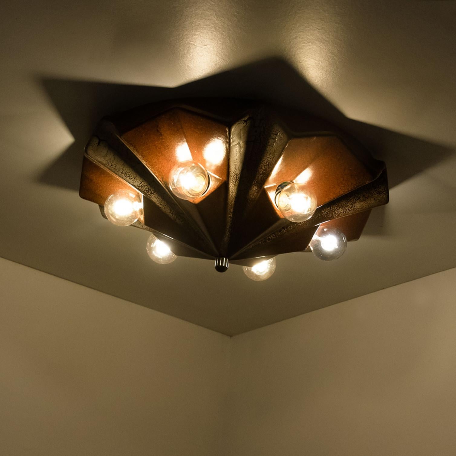 Exceptional graphical caroussel-shaped wall or ceiling lamp, made with reddish brown and beige ceramic, manufactured in the 1970s in Germany.

We used gold mirror light bulbs (see images), but silver mirror, soft gold or white light bulbs are also