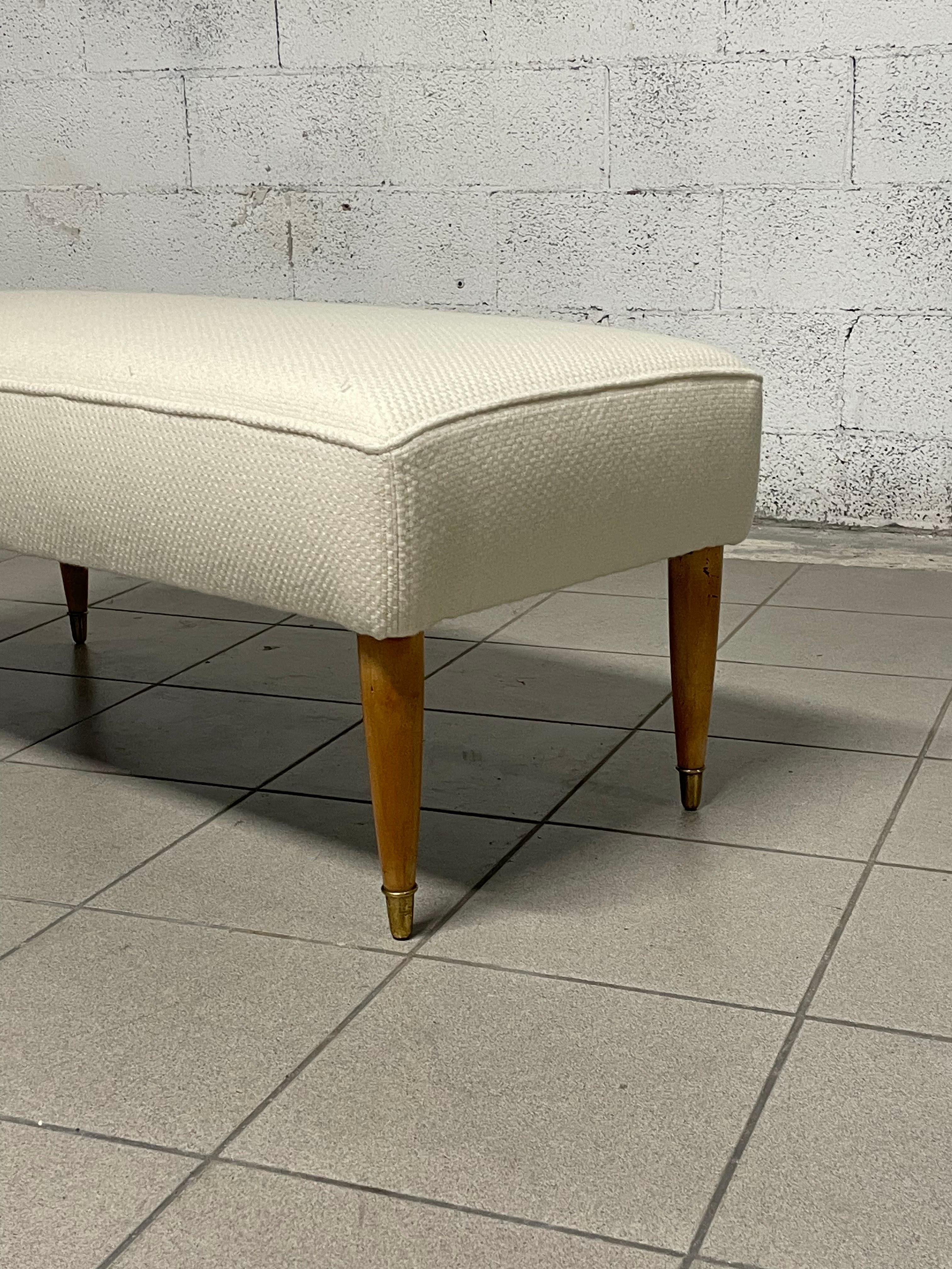 1940s bench with maple wood legs and brass ferrule.

The bench has been completely restored, new white woolen fabric upholstery.

Perfect at the end of the bed or as an entry bench.

Very convenient and easily placed in any environment.