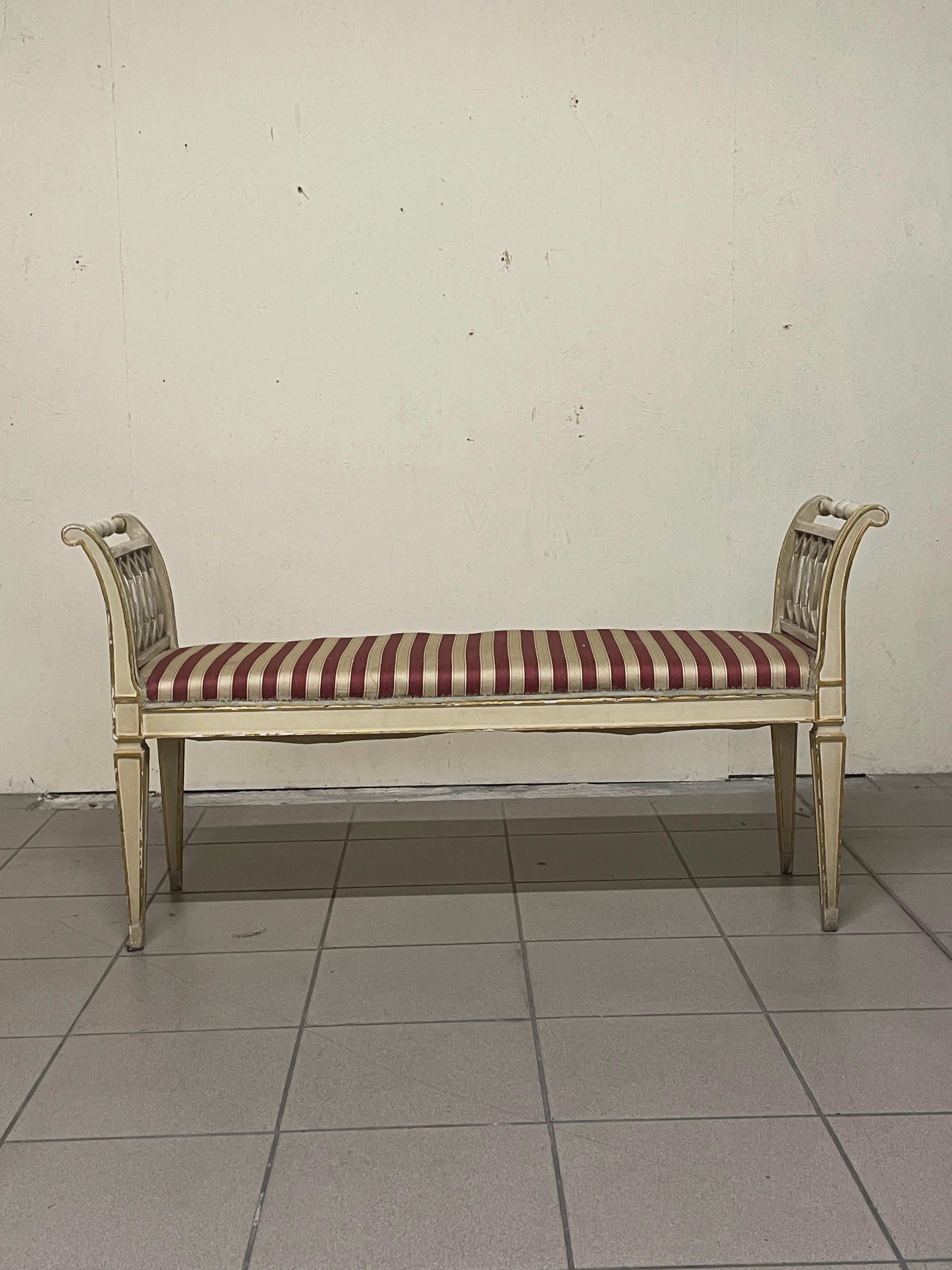 1940s directorate-style bench.

The bench has a lacquered and gilded wooden frame.
The seat is upholstered with fabric that is still original.

The wooden frame is still good but the upholstery as well as the padding are in need of redoing.

Signs