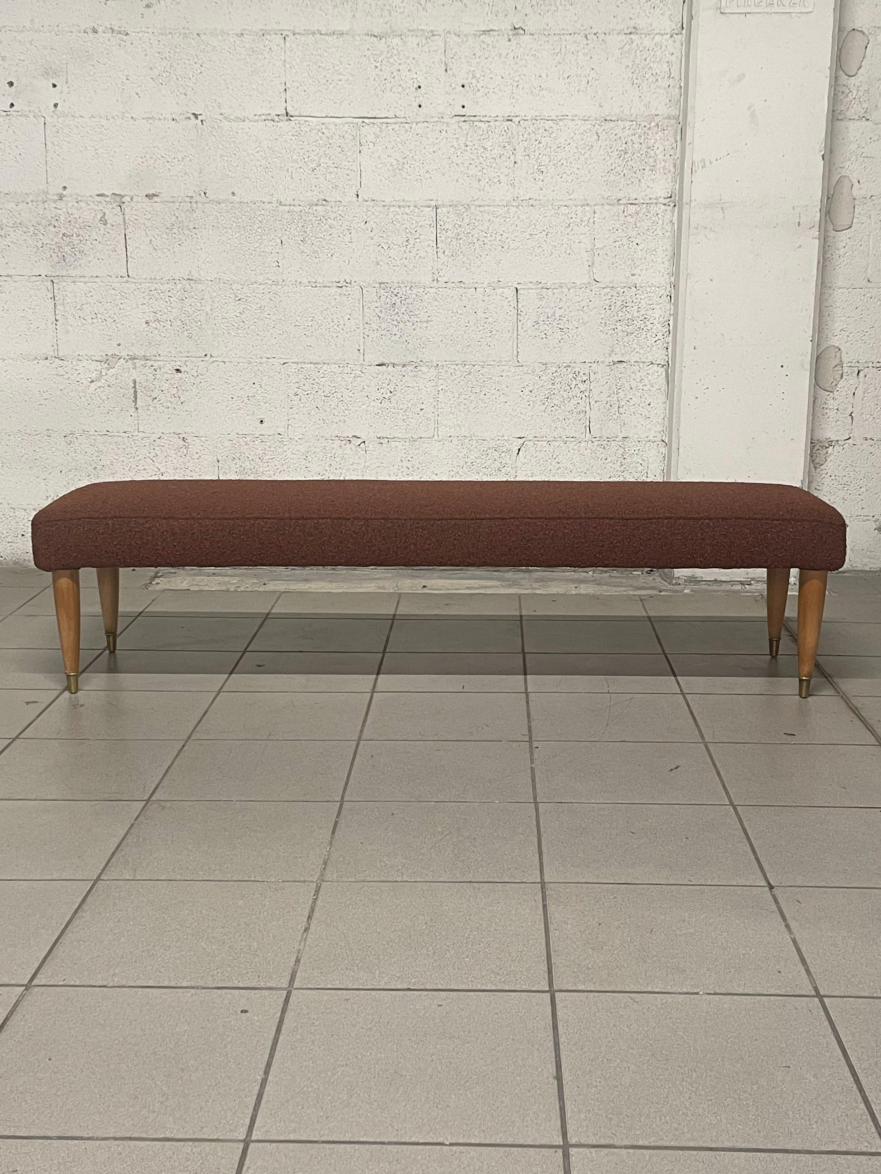 Large restored 1950s bench with maple wood legs and brass ferrules.

New rust-colored boucle' upholstery gives the bench an understated elegance in keeping with the colors of the original period.
