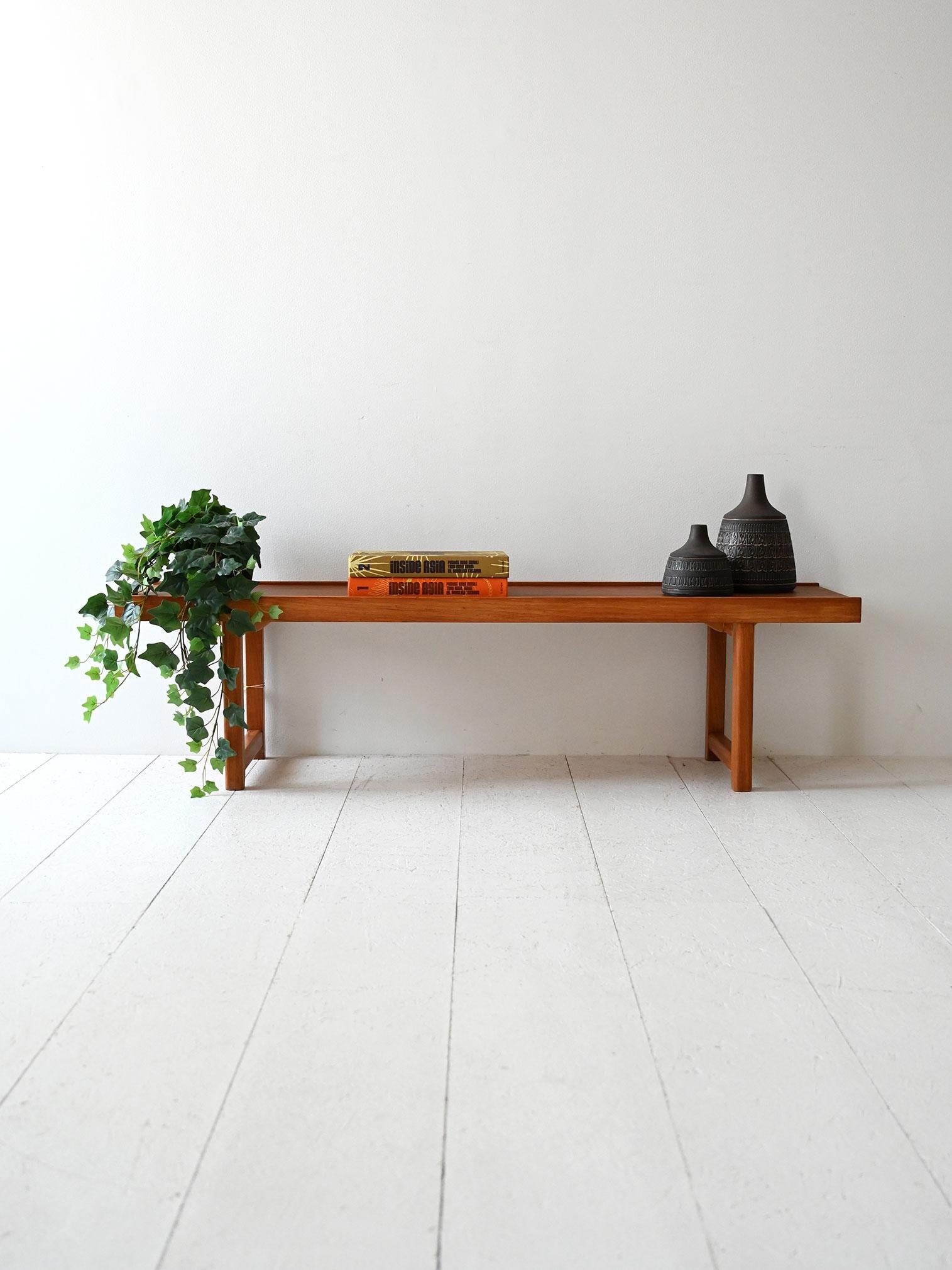Elemento in teak anni ’50/’60 con bordino rialzato e struttura leggera. Utilizzabile come panca o tavolino basso.

Mobile scandinavo vintage in teak, realizzato tra gli anni ’50 e ’60, dalle linee sobrie ed essenziali. Il piano presenta un bordo