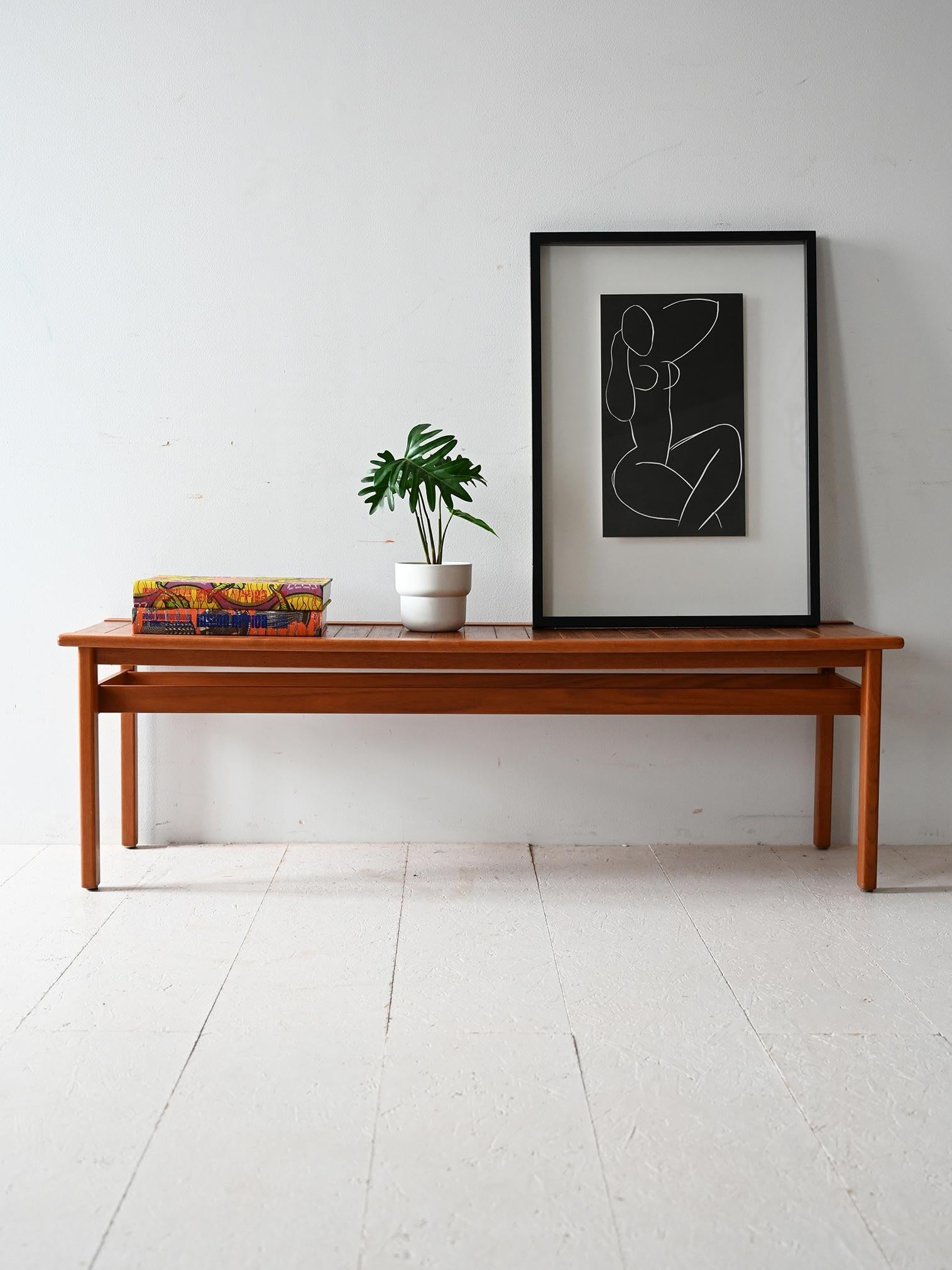 Close-set teak planked top, solid structure with exposed screws and essential lines.

Vintage Scandinavian 1960s teak bench with a close-set slatted top and sturdy solid wood frame. Exposed screws emphasize the functional and honest design approach
