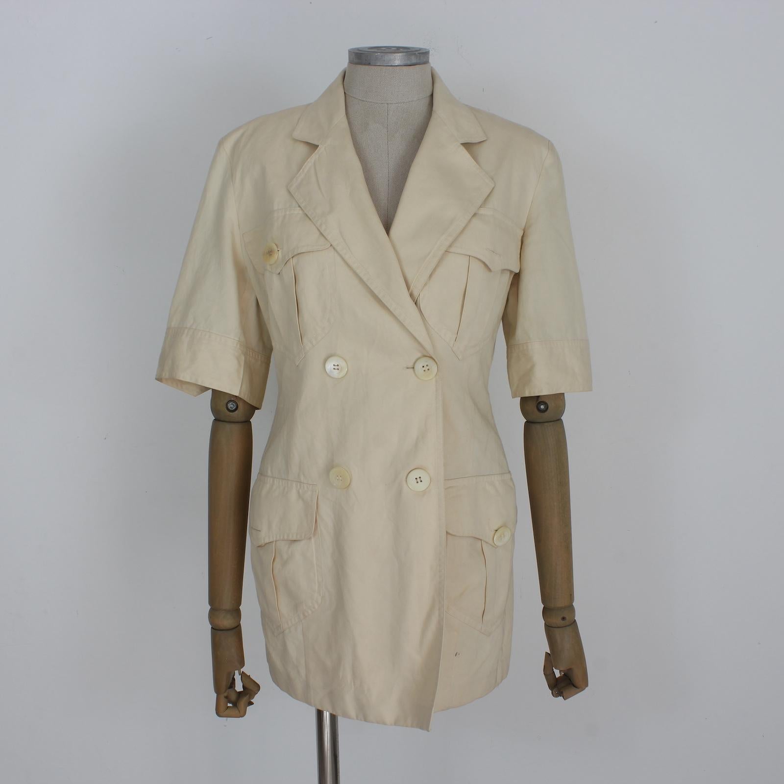 Expertly crafted by Pancaldi, this vintage 90s beige cotton jacket exudes timeless style. The double breasted design and short sleeves add a touch of sophistication. Complete with embroidered shoulders, this classic jacket is the perfect addition to