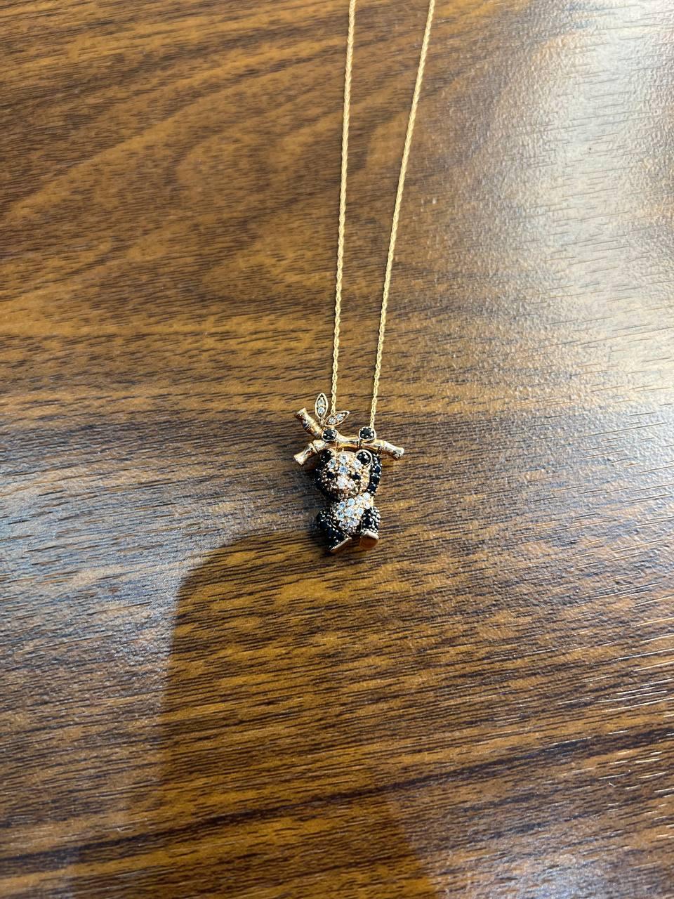 Cette pièce exquise présente un charmant design d'ours panda orné de diamants étincelants. L'ours panda est perché sur une Branch avec de délicats accents de feuilles, ajoutant une touche d'élégance inspirée de la nature. Réalisé avec une attention