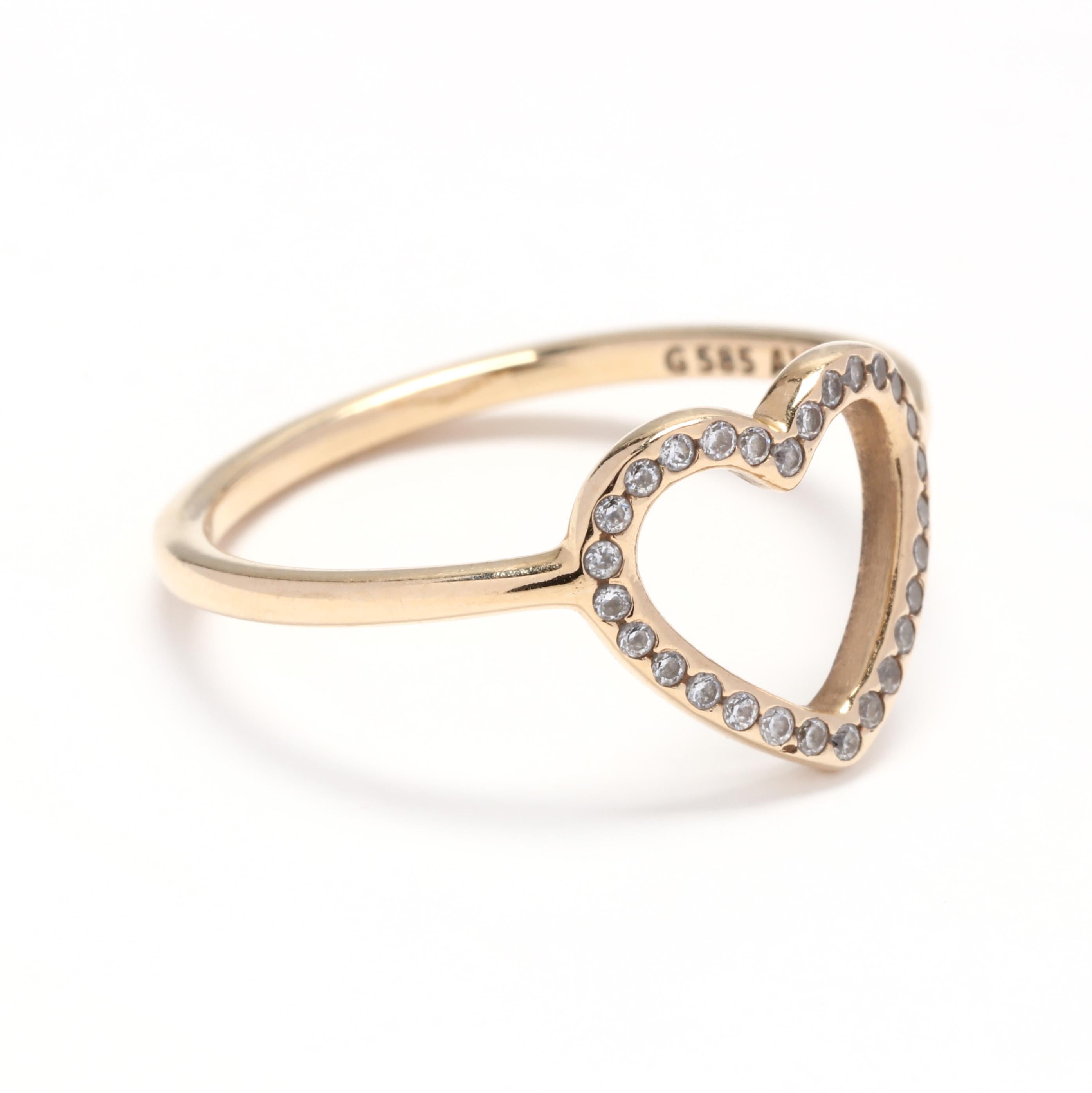 Pandora 14 karat yellow gold and colorless stone open heart ring. This ring features an open heart design set with round cut colorless stones and a thin gold band.

Ring Size 6.75

1.2 dwts.

* Please note that this is a vintage item and may show