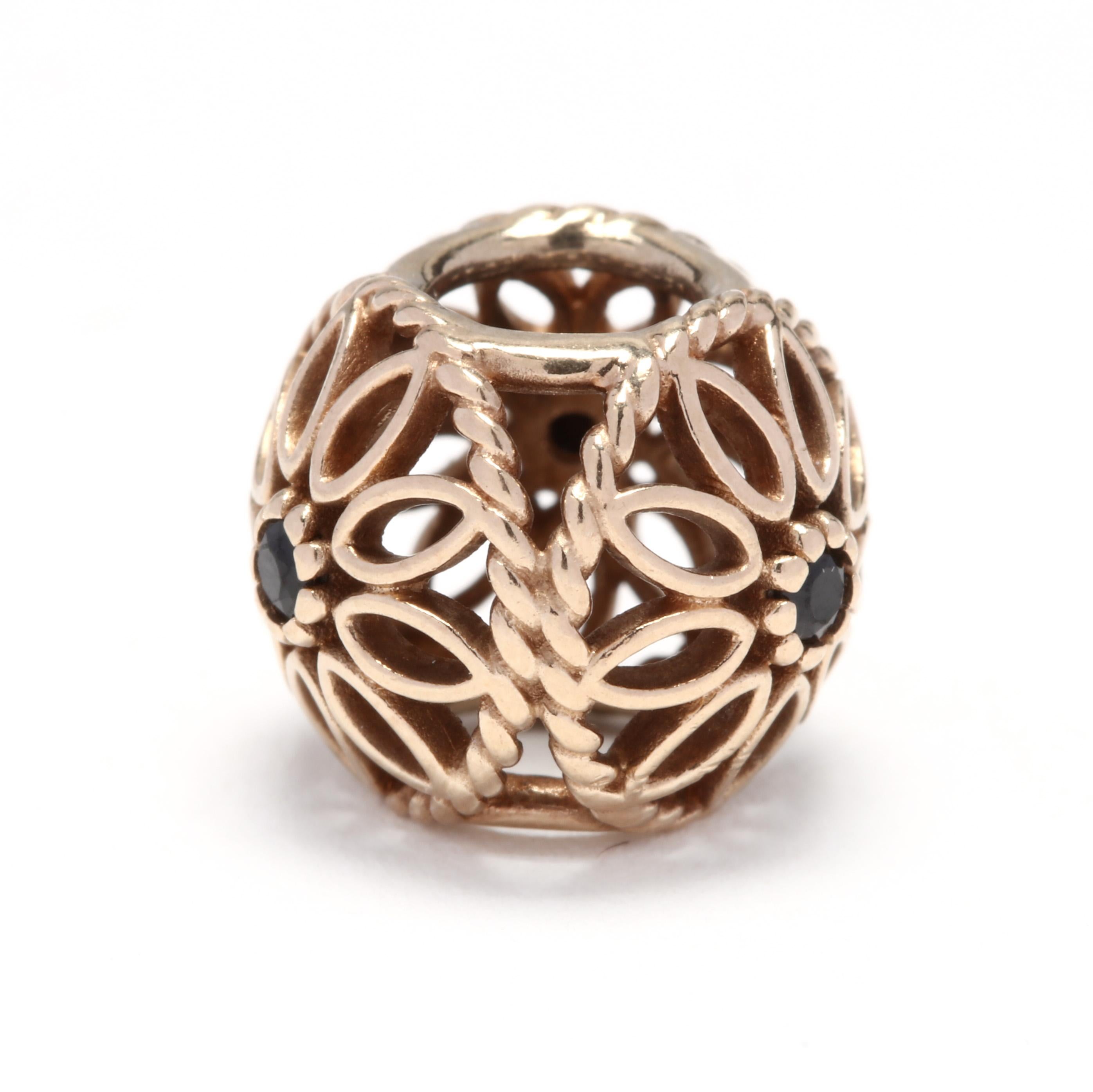 A Pandora 14 karat yellow gold and sapphire bead charm. This charm features a floral design with a bezel set, round cut sapphire in the center of each and a rope motif border.

Stones:
- sapphire
- round cut, 3 stones
- 1.75 mm

Length: 1/2