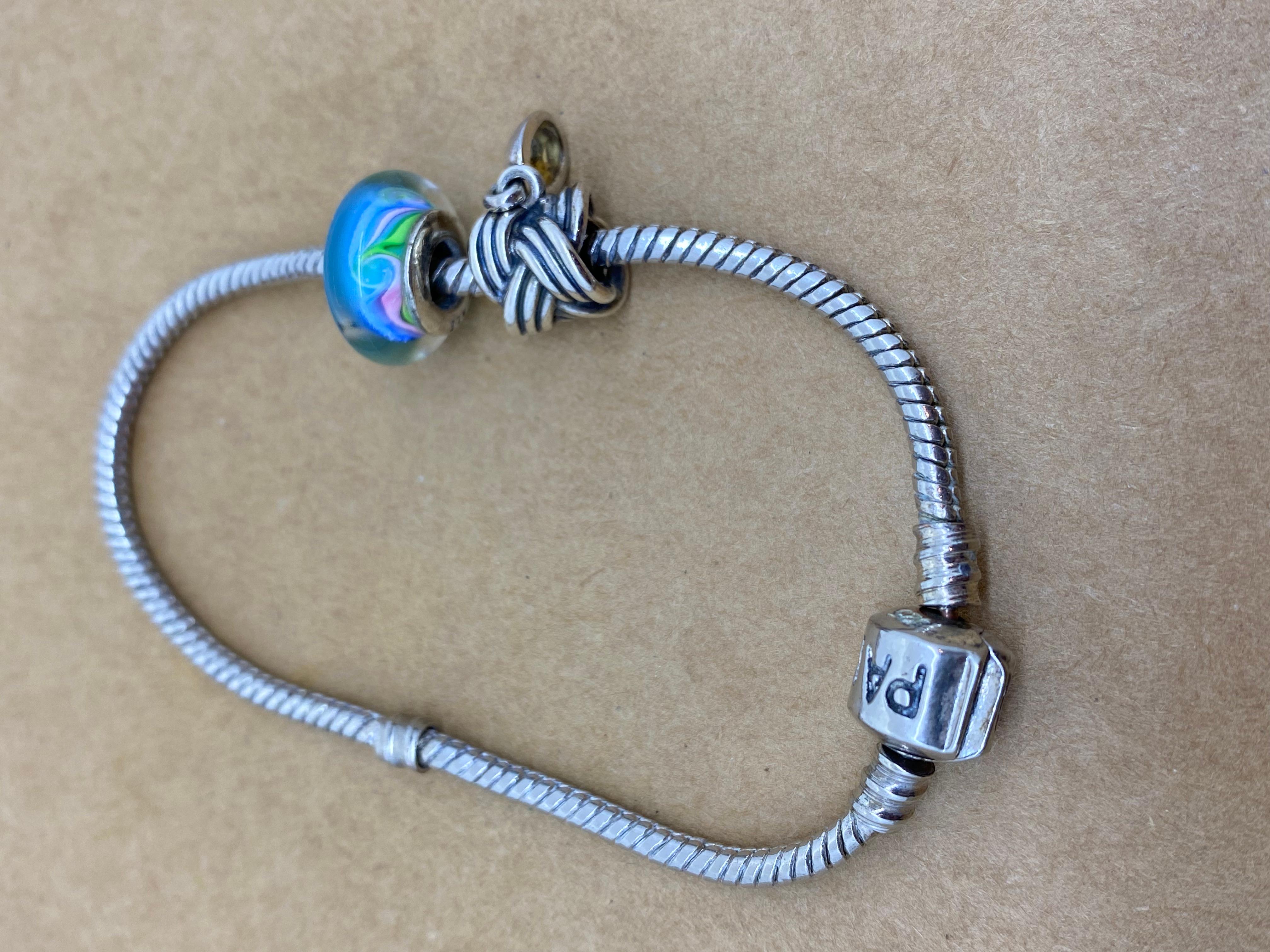 This 925 Sterling Silver Charm Bracelet by Pandora 
is comprising 2 charms,
performed in Sterling Silver,
including blue Murano glass charm

Crafted in sterling silver, 
this 21cm bracelet features an iconic Pandora clasp

Signed & stamped

Total