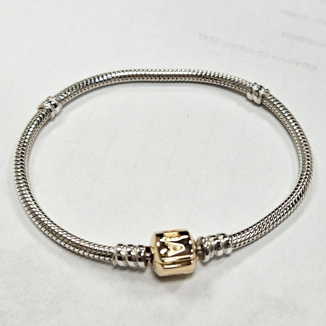 Questo elegante bracciale Pandora unisce un design senza tempo alla raffinatezza dei metalli misti. Realizzato in argento sterling, il bracciale presenta il caratteristico intreccio a catena di serpente di Pandora, noto per la sua flessibilità