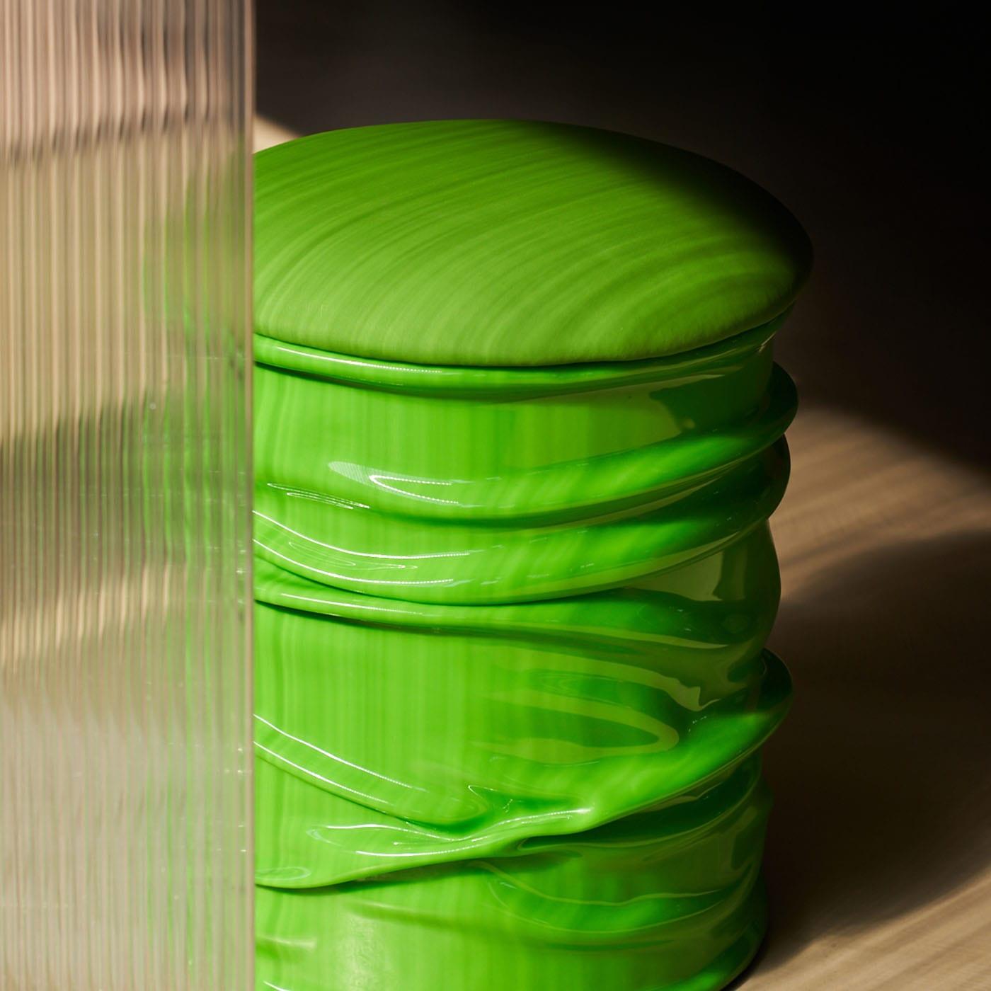 Distinguished by a vivid and polished green hue, this elegant pouf combines function and style in a singular silhouette of captivating visual allure and utmost comfort. Handcrafted of high-quality resin, it is available in a variety of custom colors