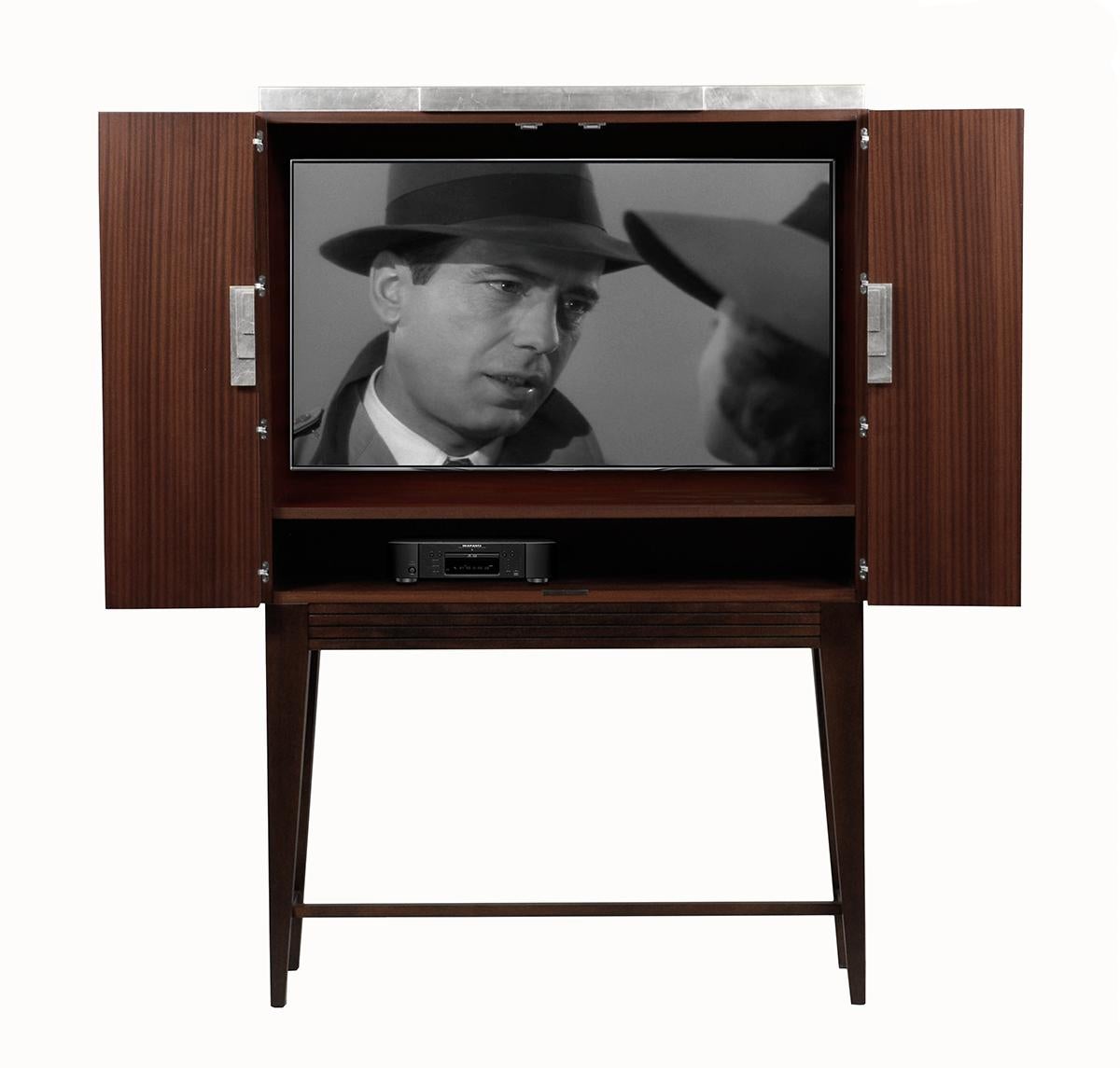 The Pandora Media Unit is a sleek and compact unit. Made with chestnut and sapeli the unit has a silver leaf trim and handle. The unit is part of the Pandora collection which consists of the Pandora cabinet and Pandora Bar. Like all of the Lee