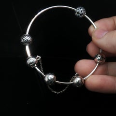 Pandora Moments Armband aus 925er Sterlingsilber mit Sicherheitskette und 5 Charms – aus einem Nachlass