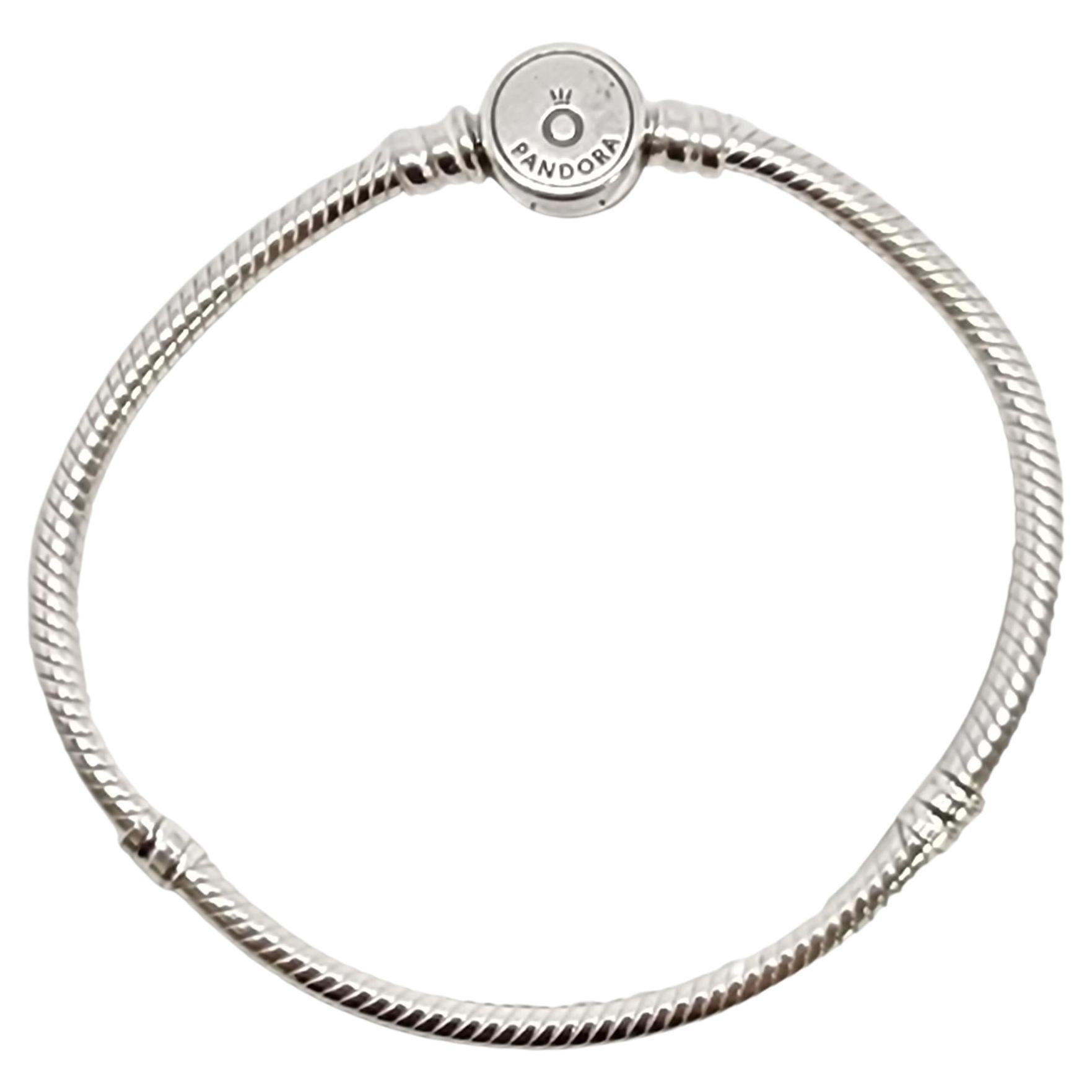 Authentic Pandora Moments Sterling Silver Sparkling Blue Disc Clasp Snake Chain Bracelet.

#599288CO1

Pandora's iconic snake chain bracelet featuring a disc clasp adorned in small blue stones on one side, and a polished back with Pandora Crown O