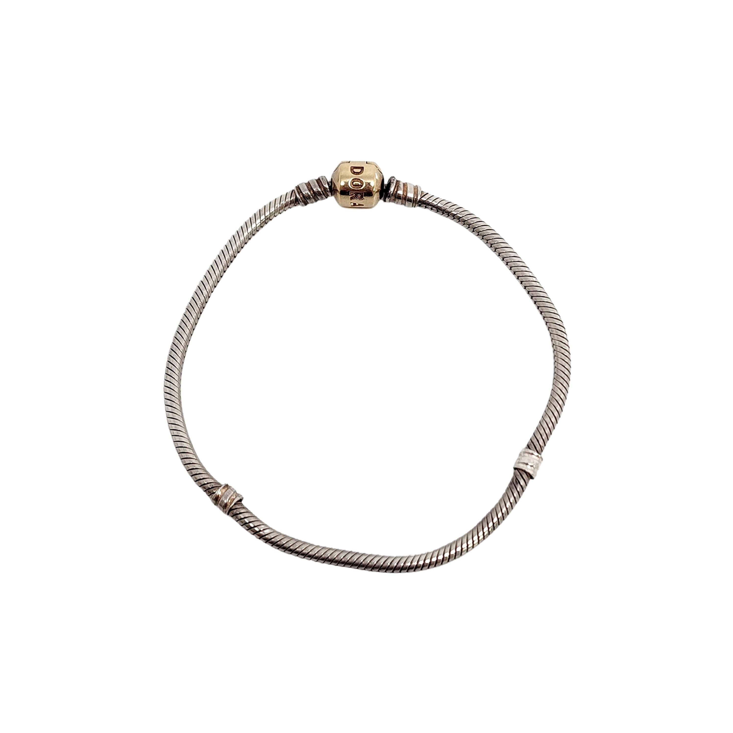 Authentic Pandora sterling silver snake chain bracelet with 14K yellow gold barrel clasp.

#590702HG

Pandora's classic charm bracelet features a snake chain and Pandora's iconic barrel clasp in 14K yellow gold for a beautiful two-tone