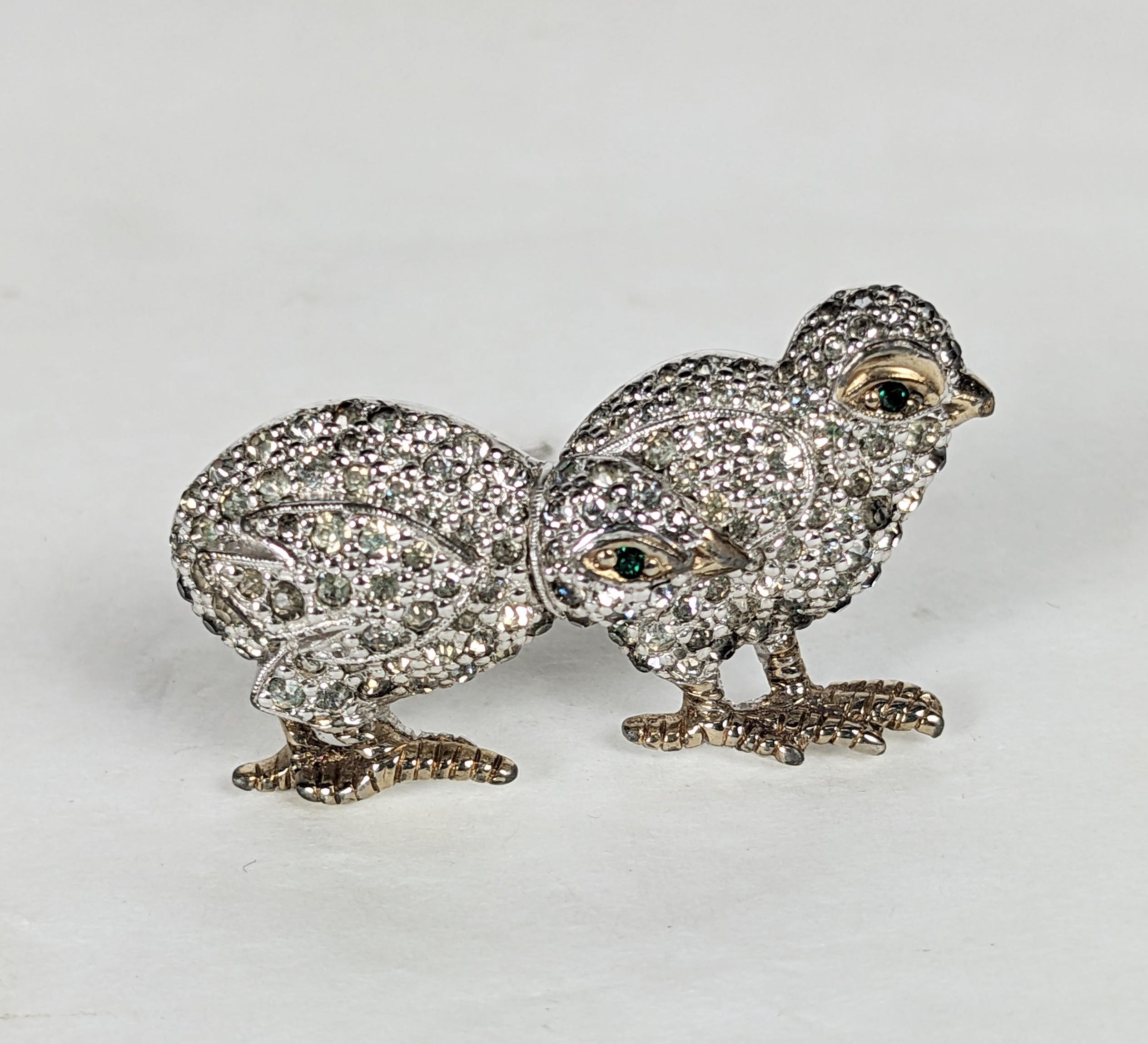 Mini broche de pareja de pollitos con pavé. De metal base rodiado con detalles chapados en oro. Engastada con pave de strass de cristal con ojos de esmeralda de imitación. Excelente estado, Panetta sin firmar. W .75 