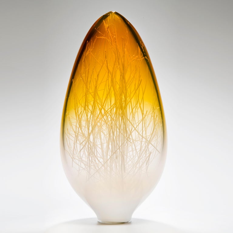 Panicum in Amber and White is a unique glass sculpture in white, clear and bright amber coloured glass by the collaborative artists Hanne Enemark (Danish) and Louis Thompson (British). The outer glass form contains a multitude of fine white canes of