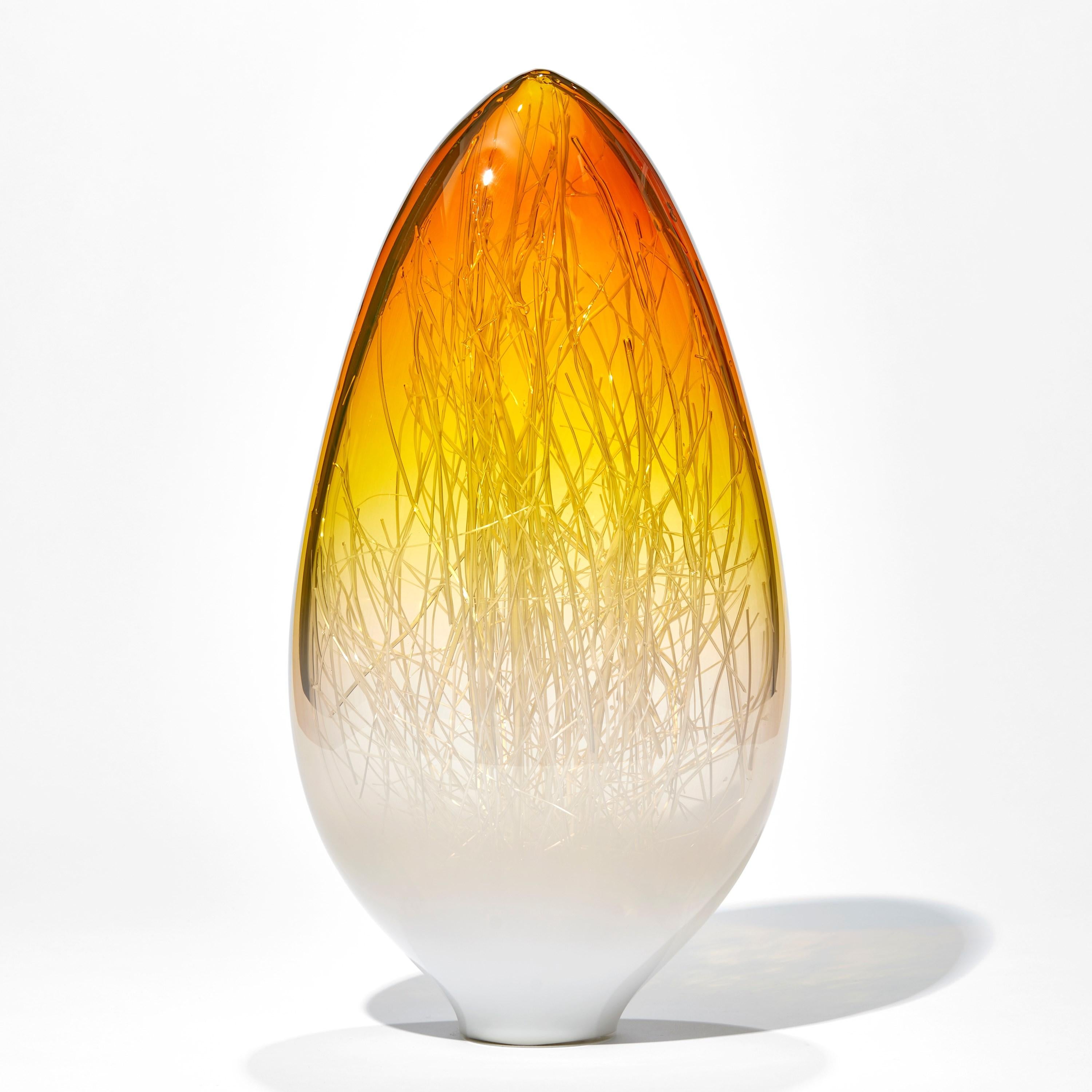 Panicum in Amber and White is a unique glass sculpture in white, clear and bright amber coloured glass by the collaborative artists Hanne Enemark (Danish) and Louis Thompson (British). The outer glass form contains a multitude of fine white canes of