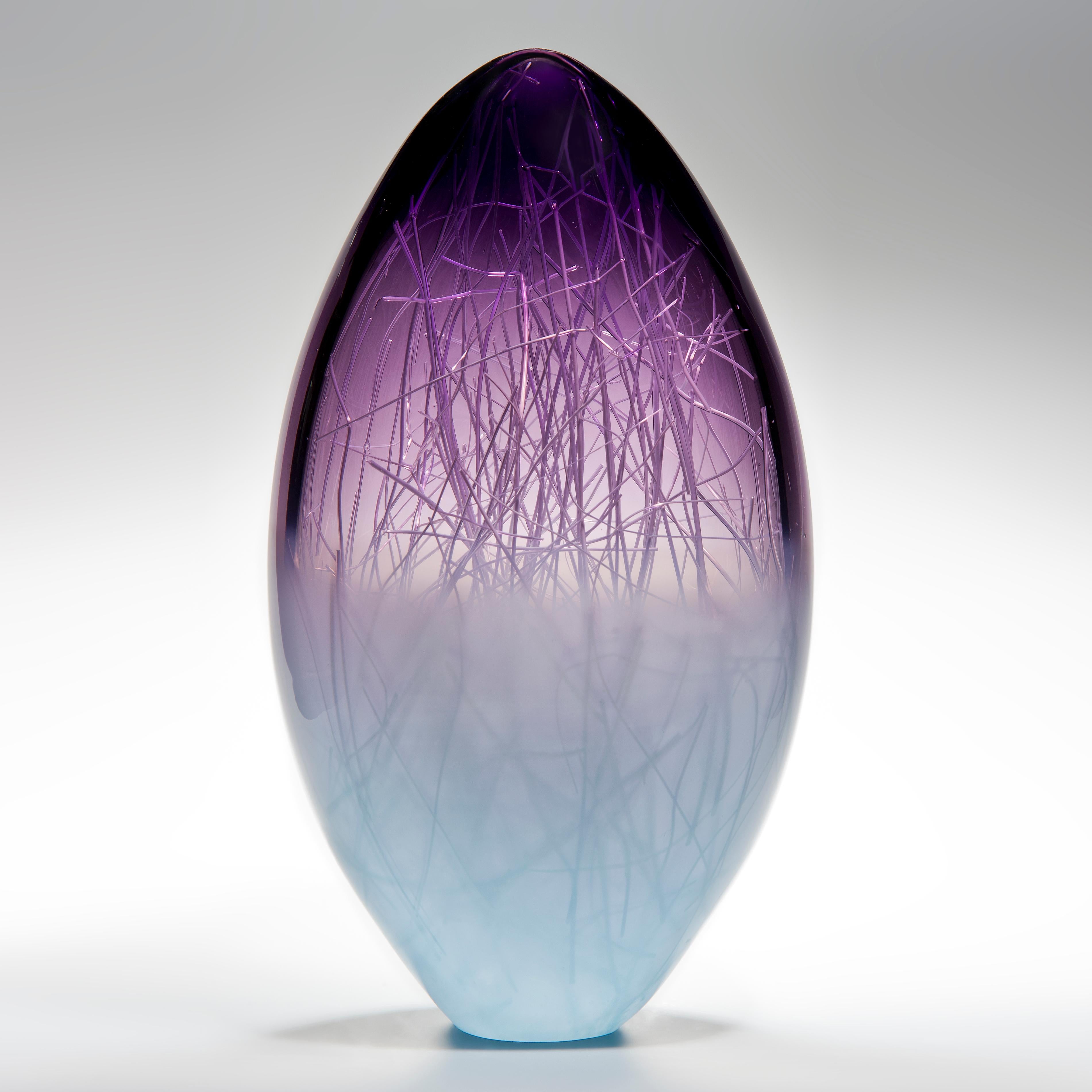 Panicum in Indigo and Pale Turquiose is a unique glass sculpture in purple and soft blue coloured glass by the collaborative artists Hanne Enemark (Danish) and Louis Thompson (British). The outer glass form contains a multitude of fine white canes
